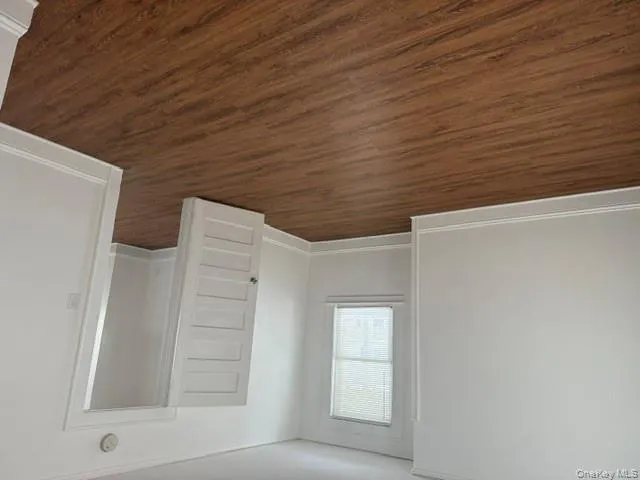 Spare room featuring dark wood-type flooring and baseboards Spare room featuring dark wood-type flooring and baseboards