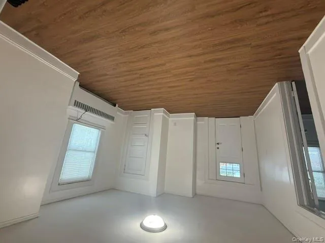 Entryway featuring dark wood-style flooring, radiator, and crown molding Entryway featuring dark wood-style flooring, radiator, and crown molding