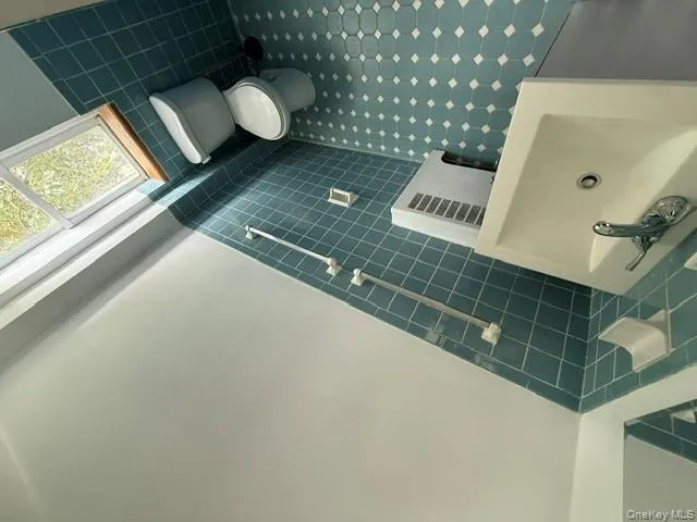 Bathroom with tile walls, wainscoting, tile patterned floors, and vanity Bathroom with tile walls, wainscoting, tile patterned floors, and vanity