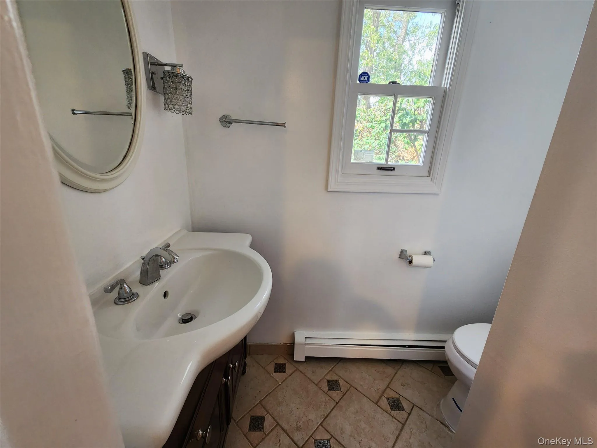 Bathroom with vanity, baseboard heating, and tile patterned flooring Bathroom with vanity, baseboard heating, and tile patterned flooring