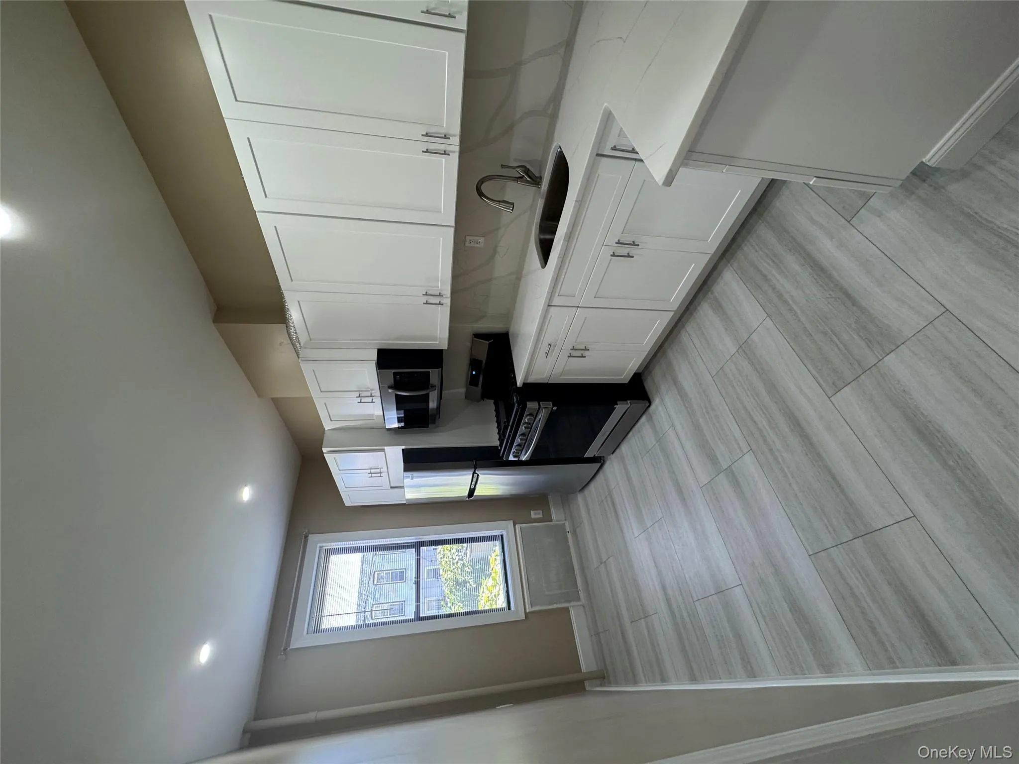 Kitchen with white cabinets, appliances with stainless steel finishes, light stone counters, and recessed lighting Kitchen with white cabinets, appliances with stainless steel finishes, light stone counters, and recessed lighting