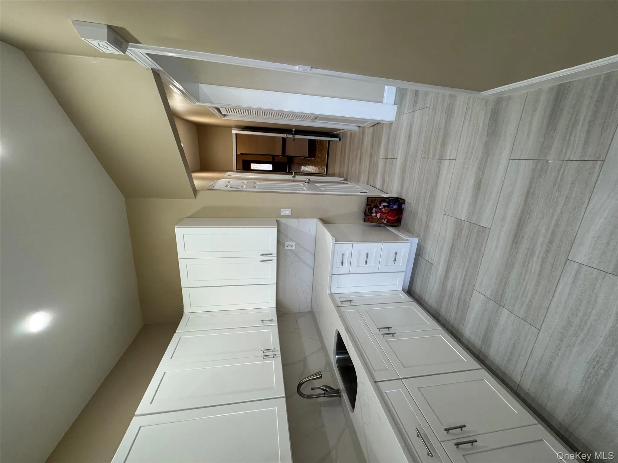 Kitchen featuring white cabinetry, light stone countertops, backsplash, and recessed lighting Kitchen featuring white cabinetry, light stone countertops, backsplash, and recessed lighting
