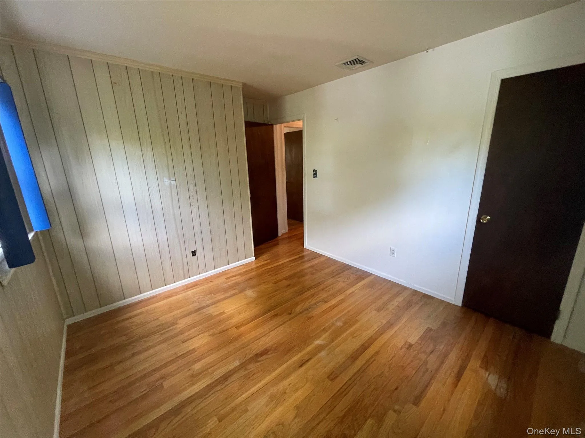 Empty room featuring wood walls and light wood finished floors Empty room featuring wood walls and light wood finished floors