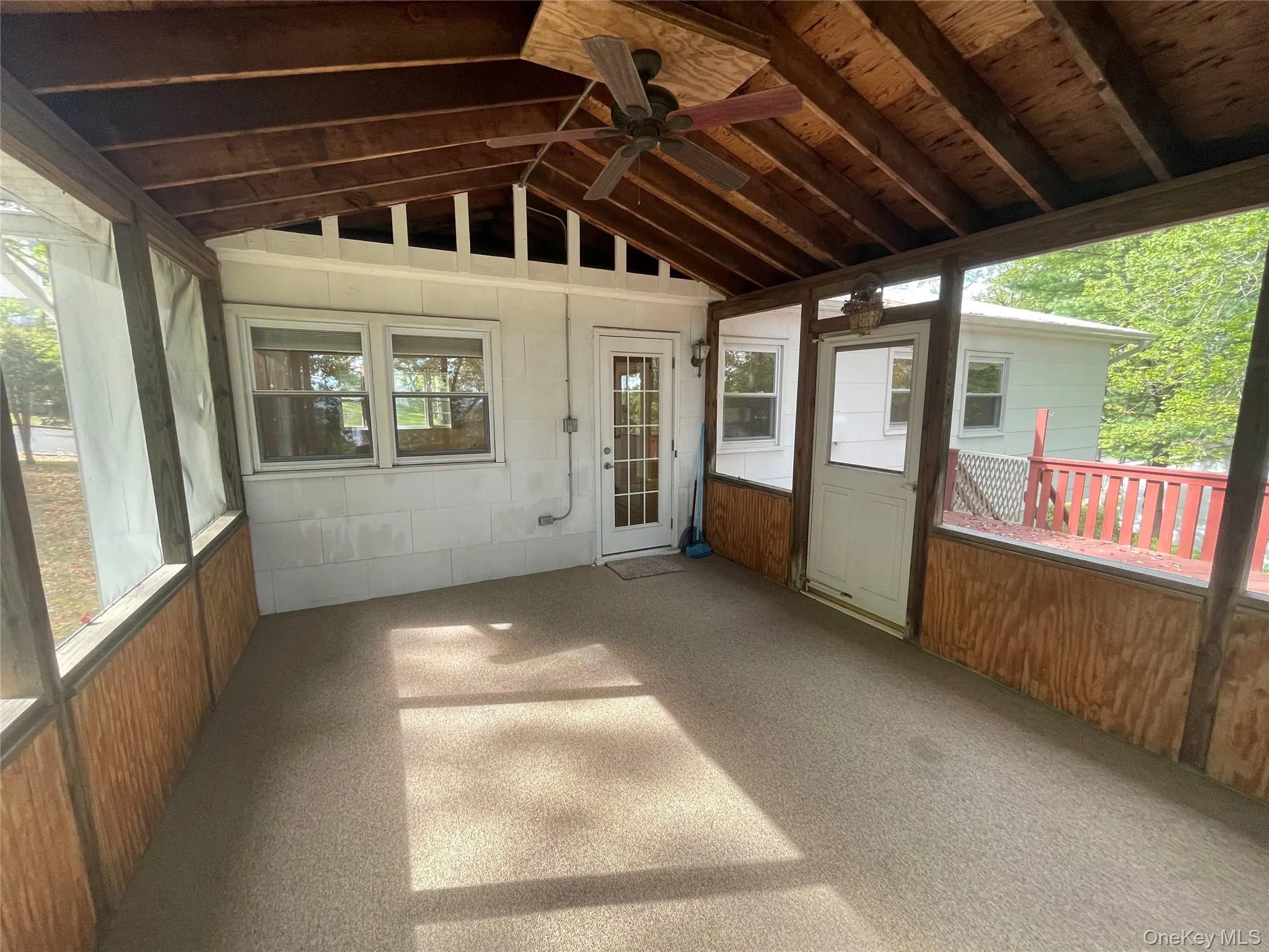 Unfurnished sunroom featuring ceiling fan, vaulted ceiling, and a patio area Unfurnished sunroom featuring ceiling fan, vaulted ceiling, and a patio area