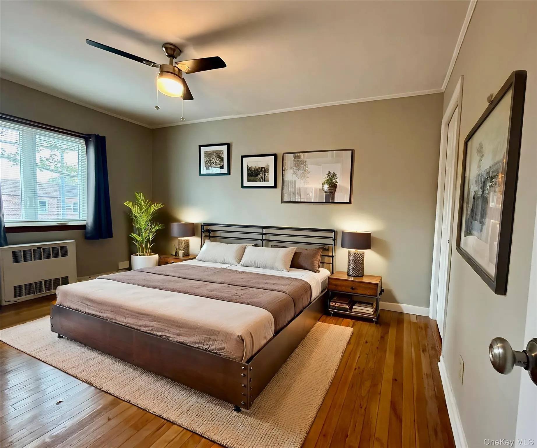 Bedroom featuring radiator heating unit, hardwood / wood-style flooring, crown molding, and ceiling fan Bedroom featuring radiator heating unit, hardwood / wood-style flooring, crown molding, and ceiling fan