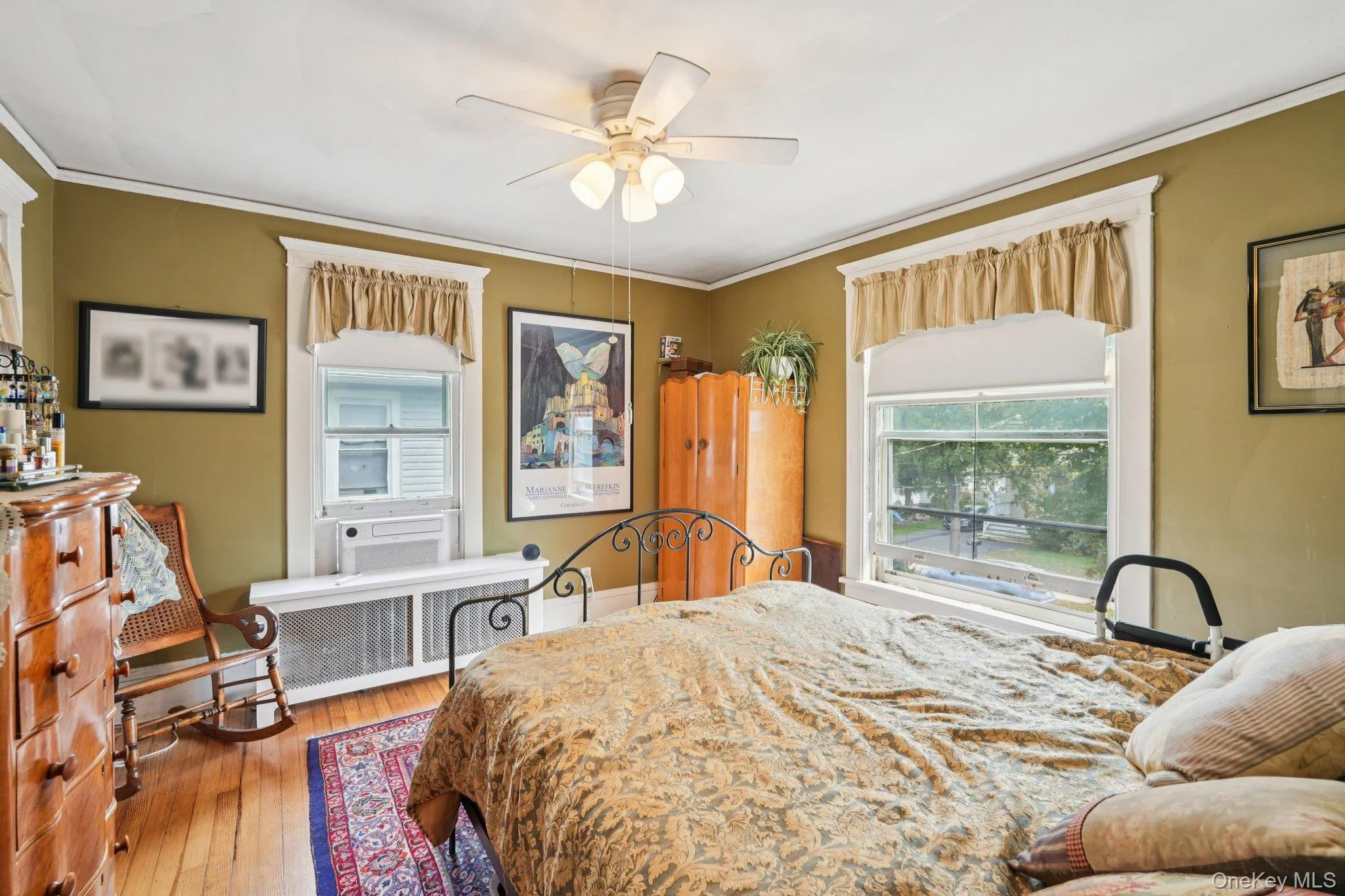 Bedroom featuring crown molding, light wood-style floors, radiator heating unit, and ceiling fan Bedroom featuring crown molding, light wood-style floors, radiator heating unit, and ceiling fan
