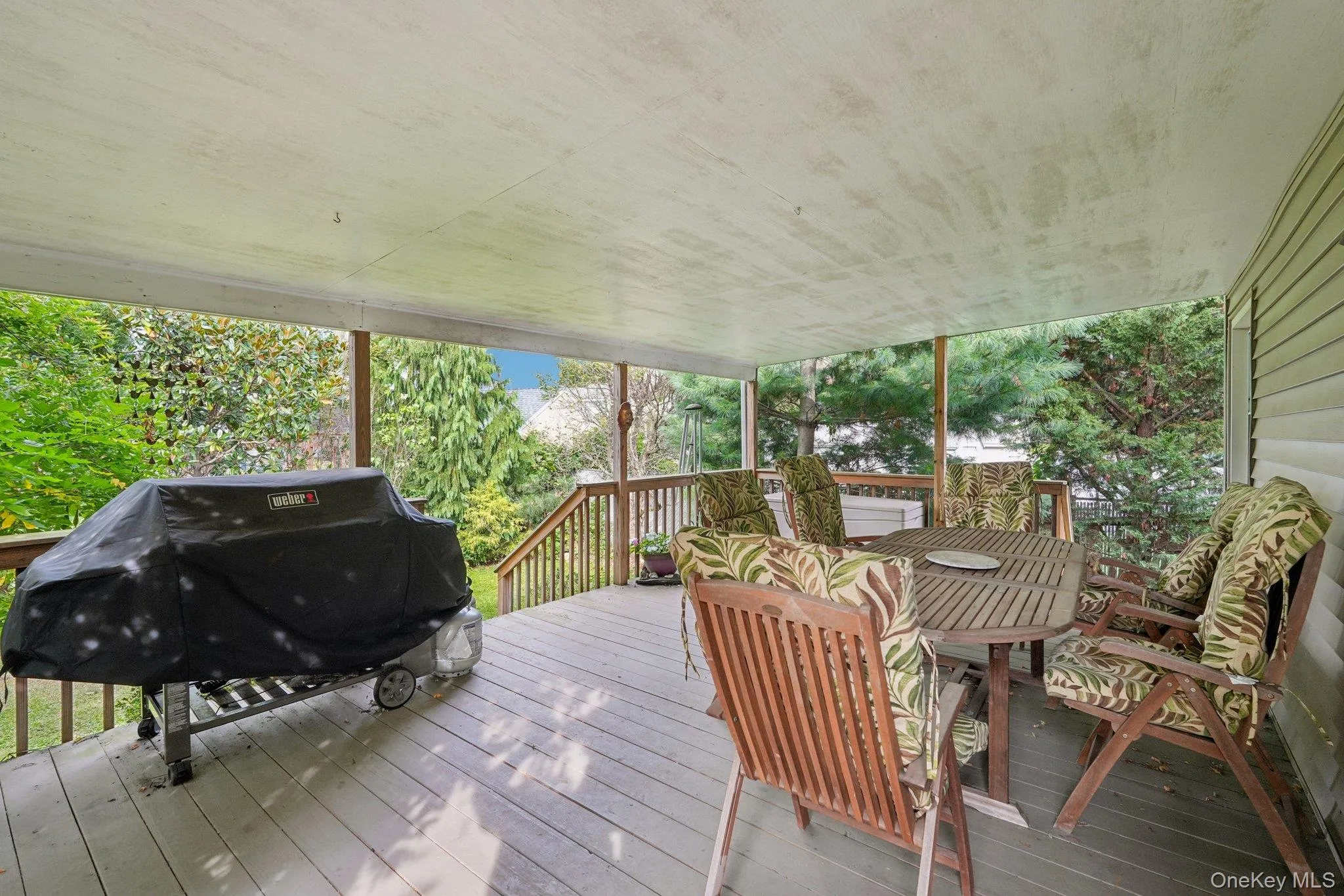Wooden deck featuring a grill and outdoor dining area Wooden deck featuring a grill and outdoor dining area