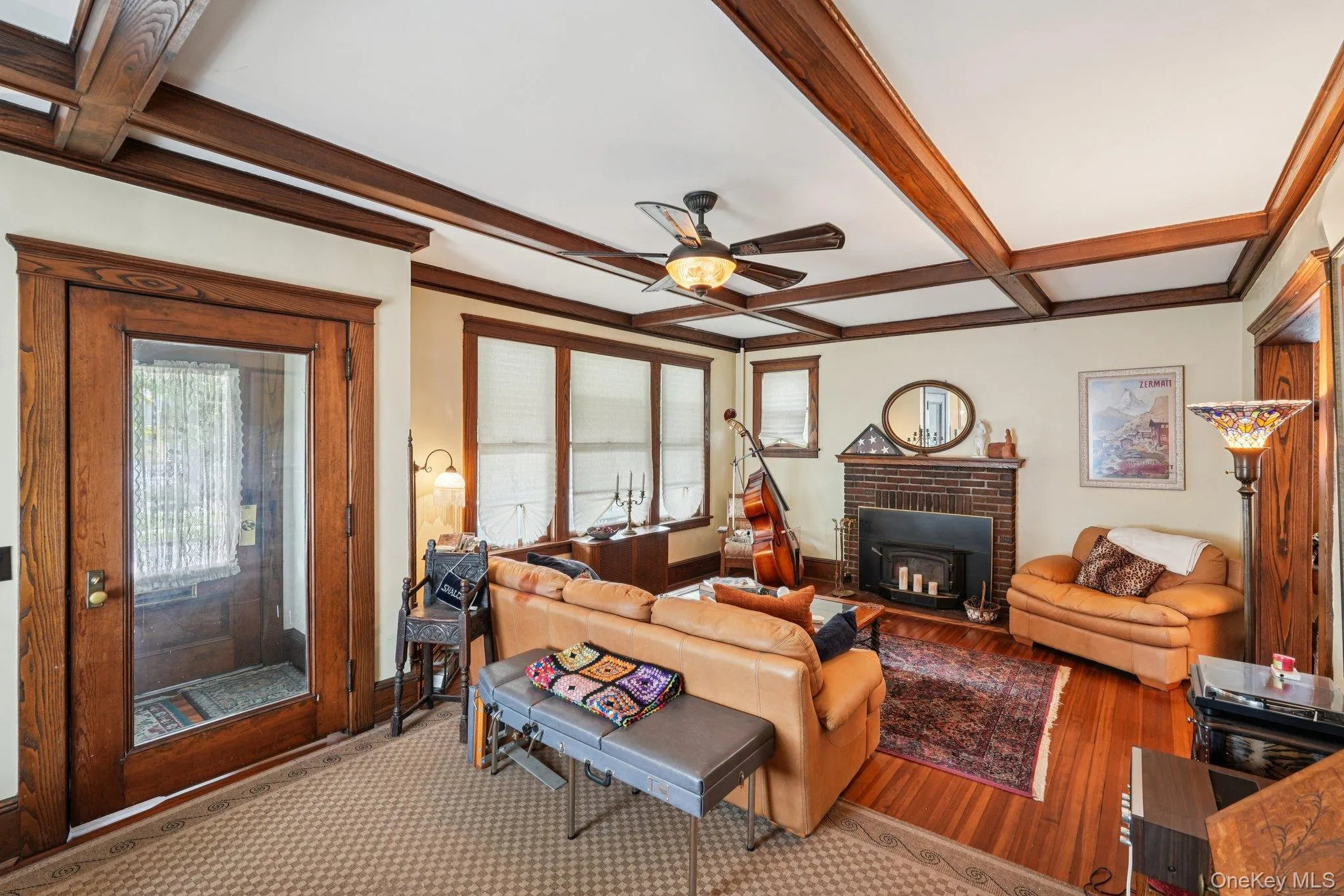 Living area with beamed ceiling, coffered ceiling, healthy amount of natural light, ceiling fan, and wood finished floors Living area with beamed ceiling, coffered ceiling, healthy amount of natural light, ceiling fan, and wood finished floors