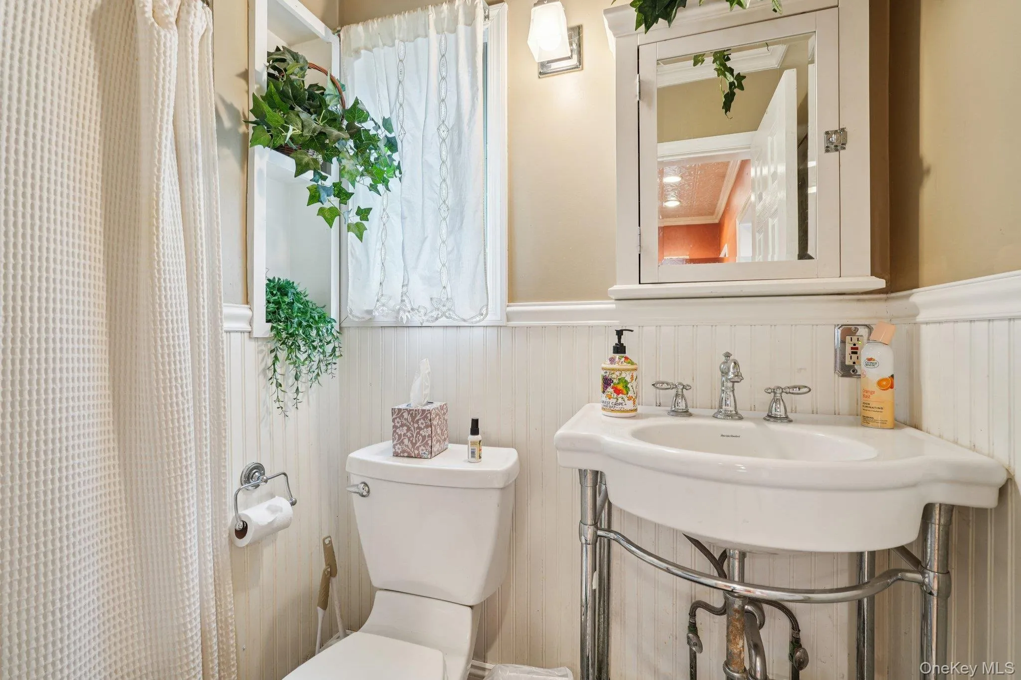 Full bath featuring toilet and a wainscoted wall Full bath featuring toilet and a wainscoted wall