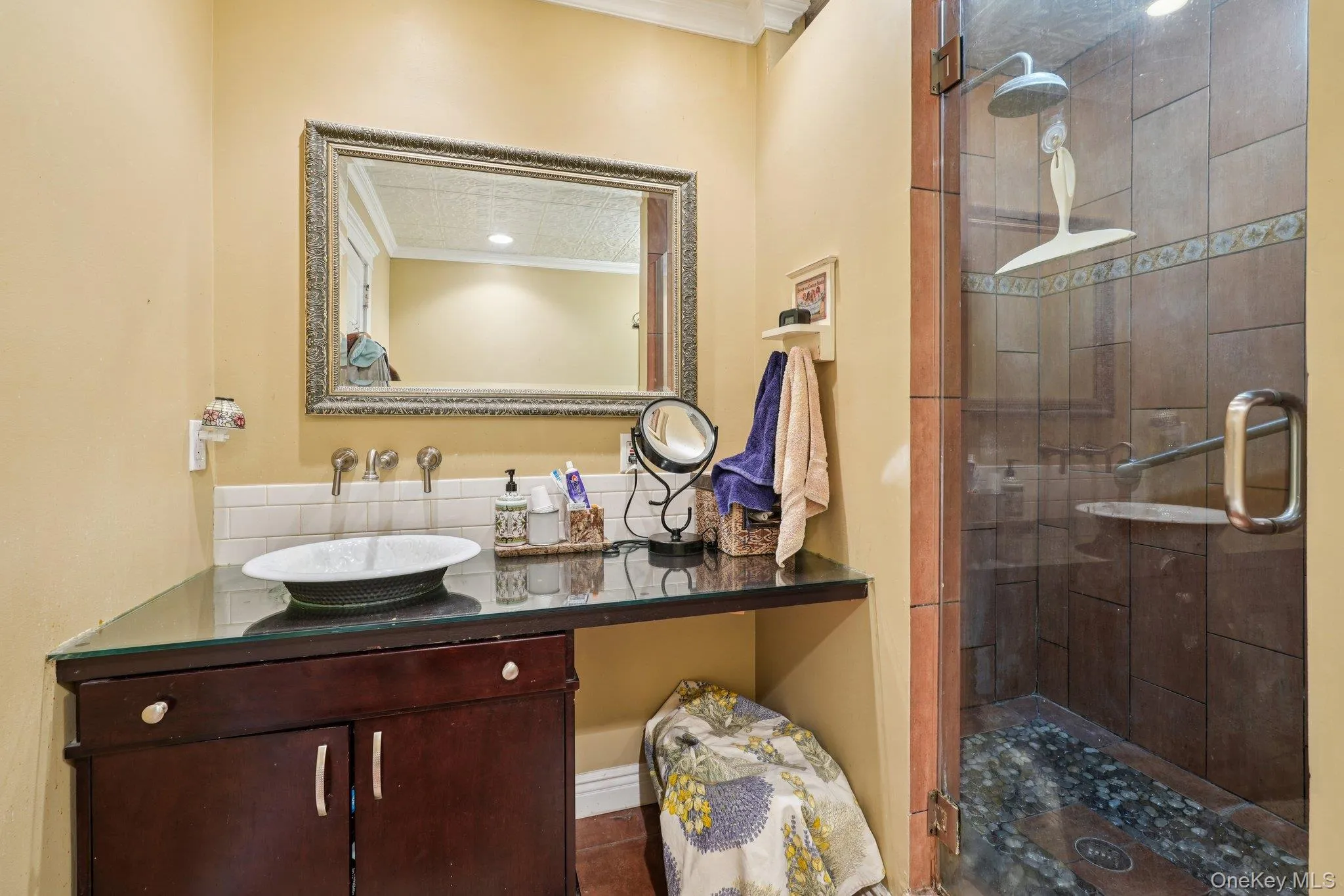 Bathroom featuring a shower stall, ornamental molding, and vanity Bathroom featuring a shower stall, ornamental molding, and vanity