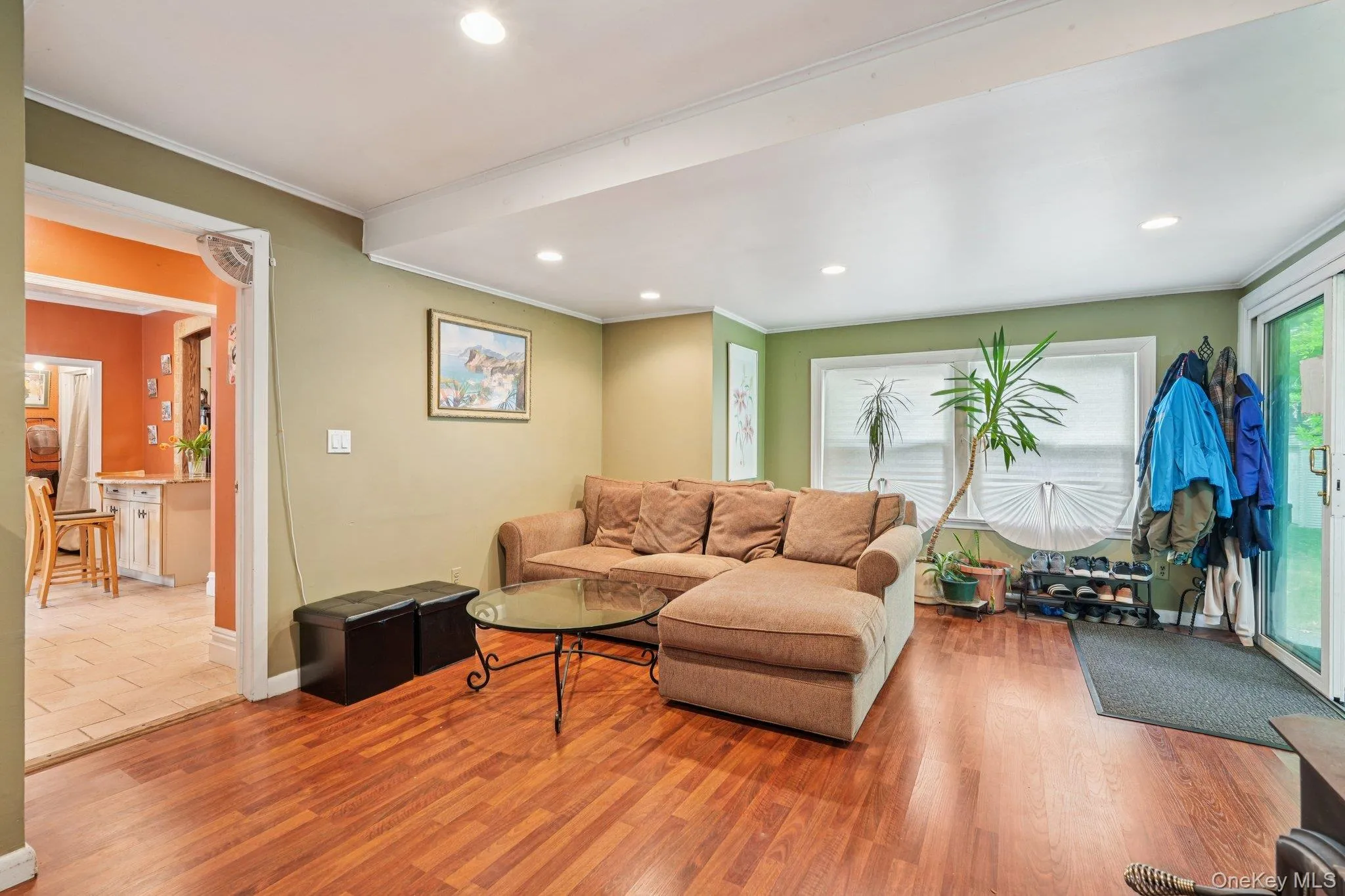 Living area featuring wood finished floors, recessed lighting, and ornamental molding Living area featuring wood finished floors, recessed lighting, and ornamental molding