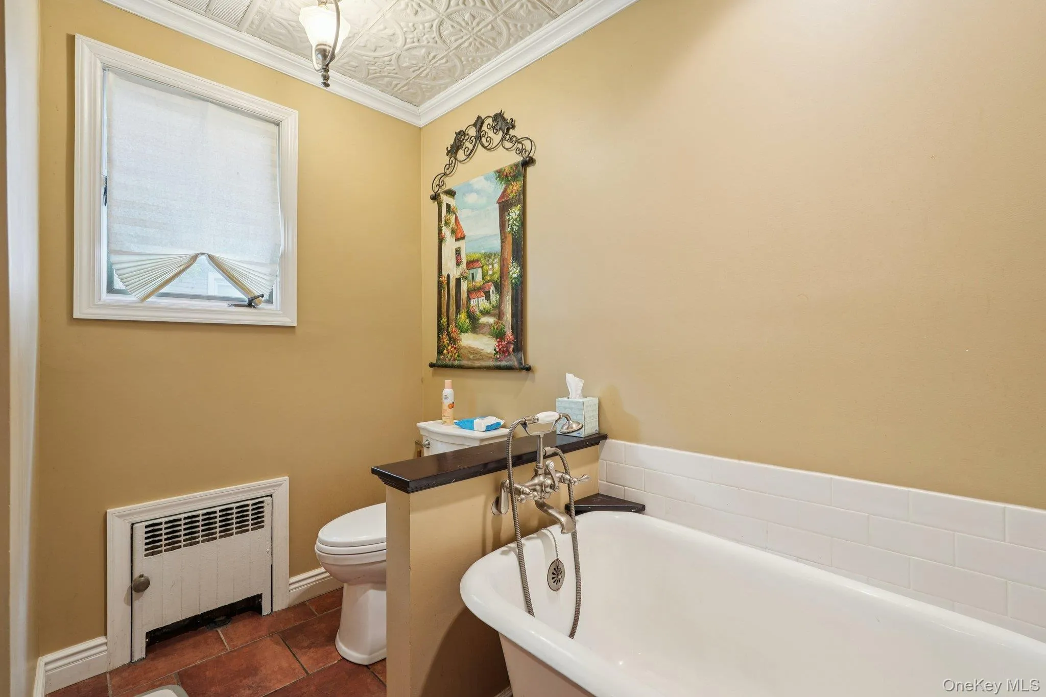 Full bathroom featuring a freestanding tub, an ornate ceiling, radiator, crown molding, and dark tile patterned floors Full bathroom featuring a freestanding tub, an ornate ceiling, radiator, crown molding, and dark tile patterned floors