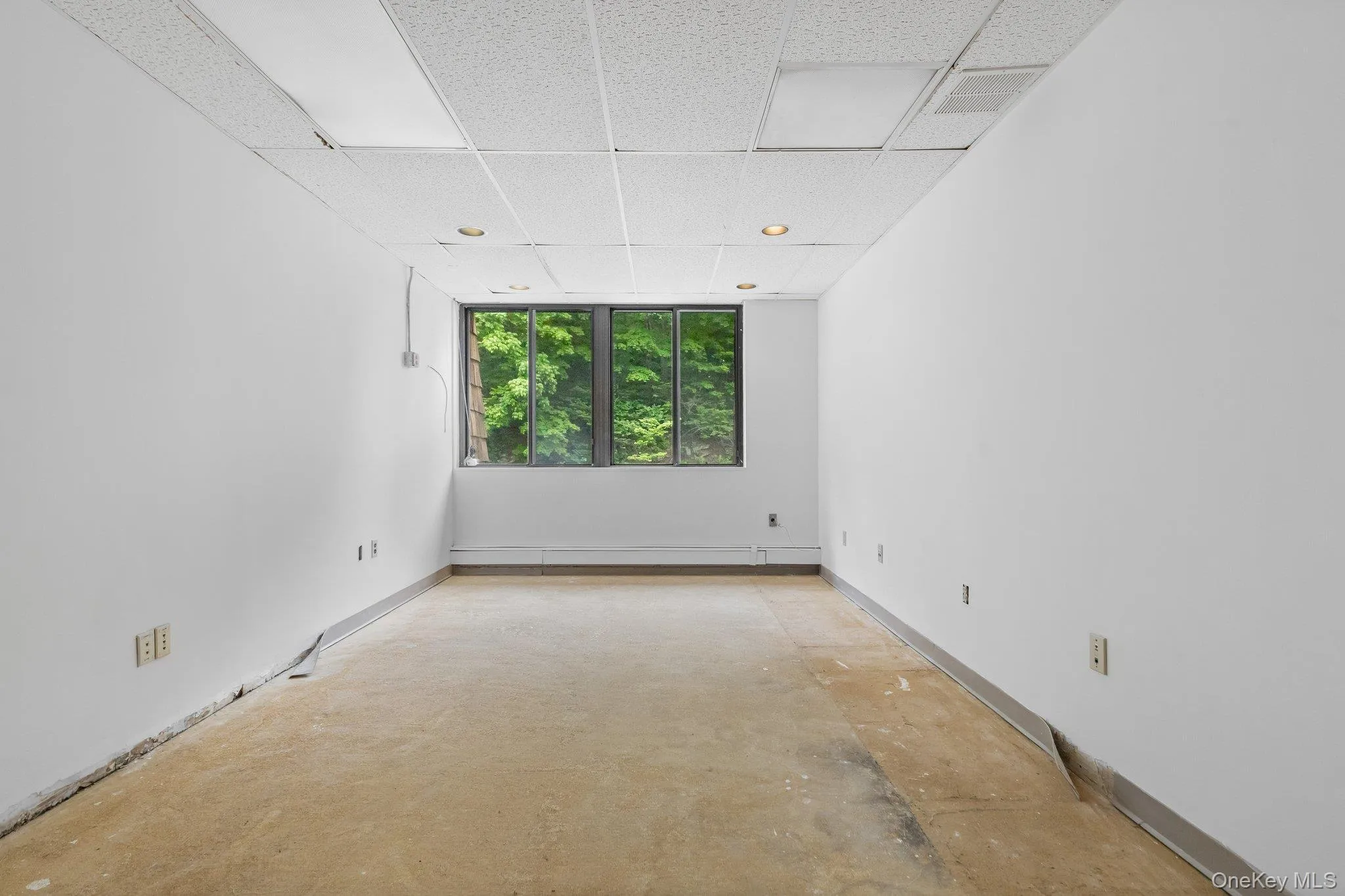 Unfurnished room featuring a drop ceiling and concrete floors Unfurnished room featuring a drop ceiling and concrete floors