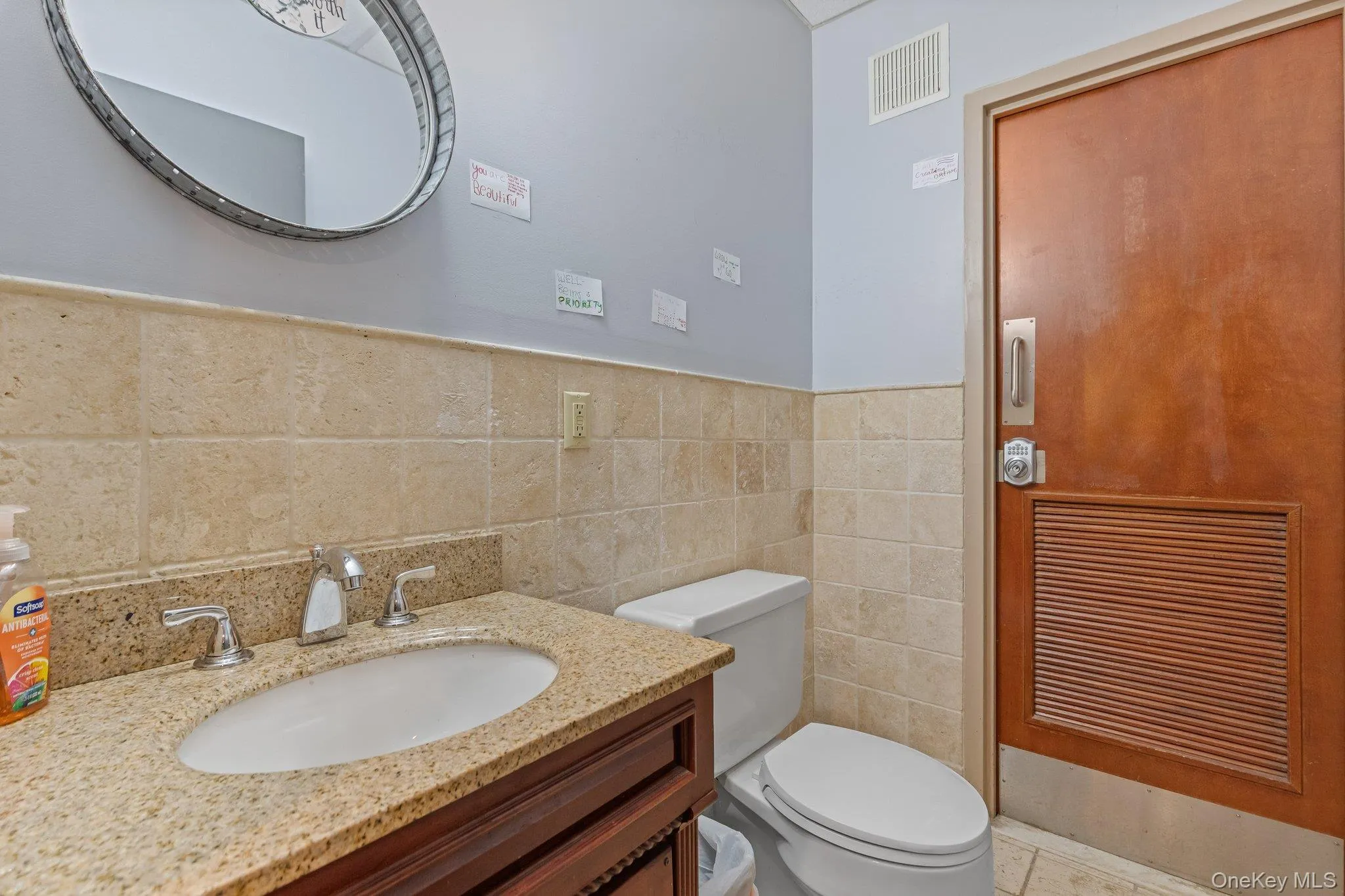 Bathroom featuring vanity and tile walls Bathroom featuring vanity and tile walls