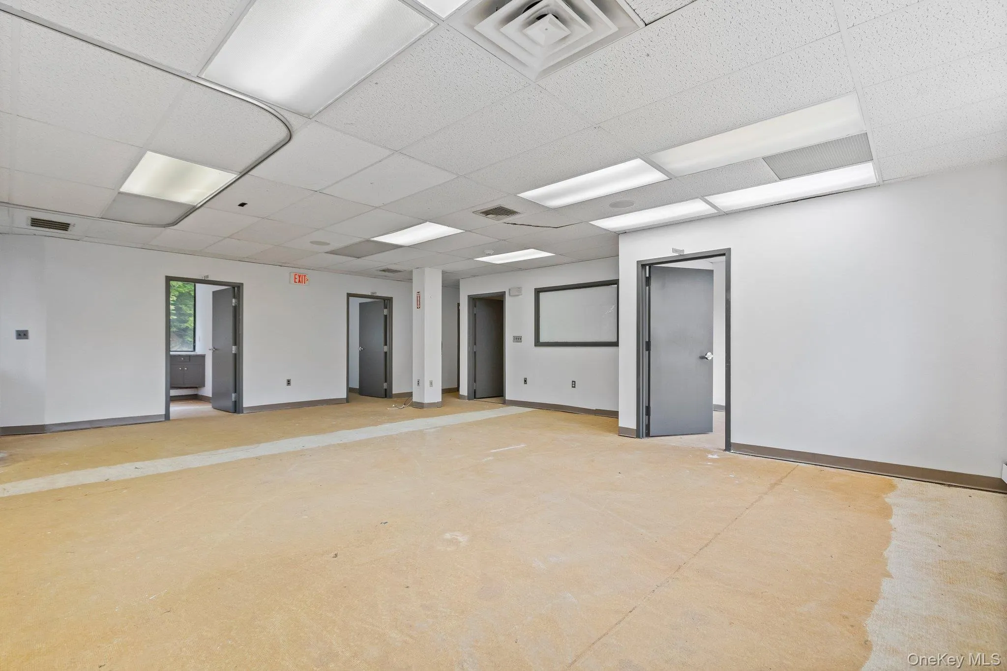 Empty room featuring a drop ceiling and concrete flooring Empty room featuring a drop ceiling and concrete flooring