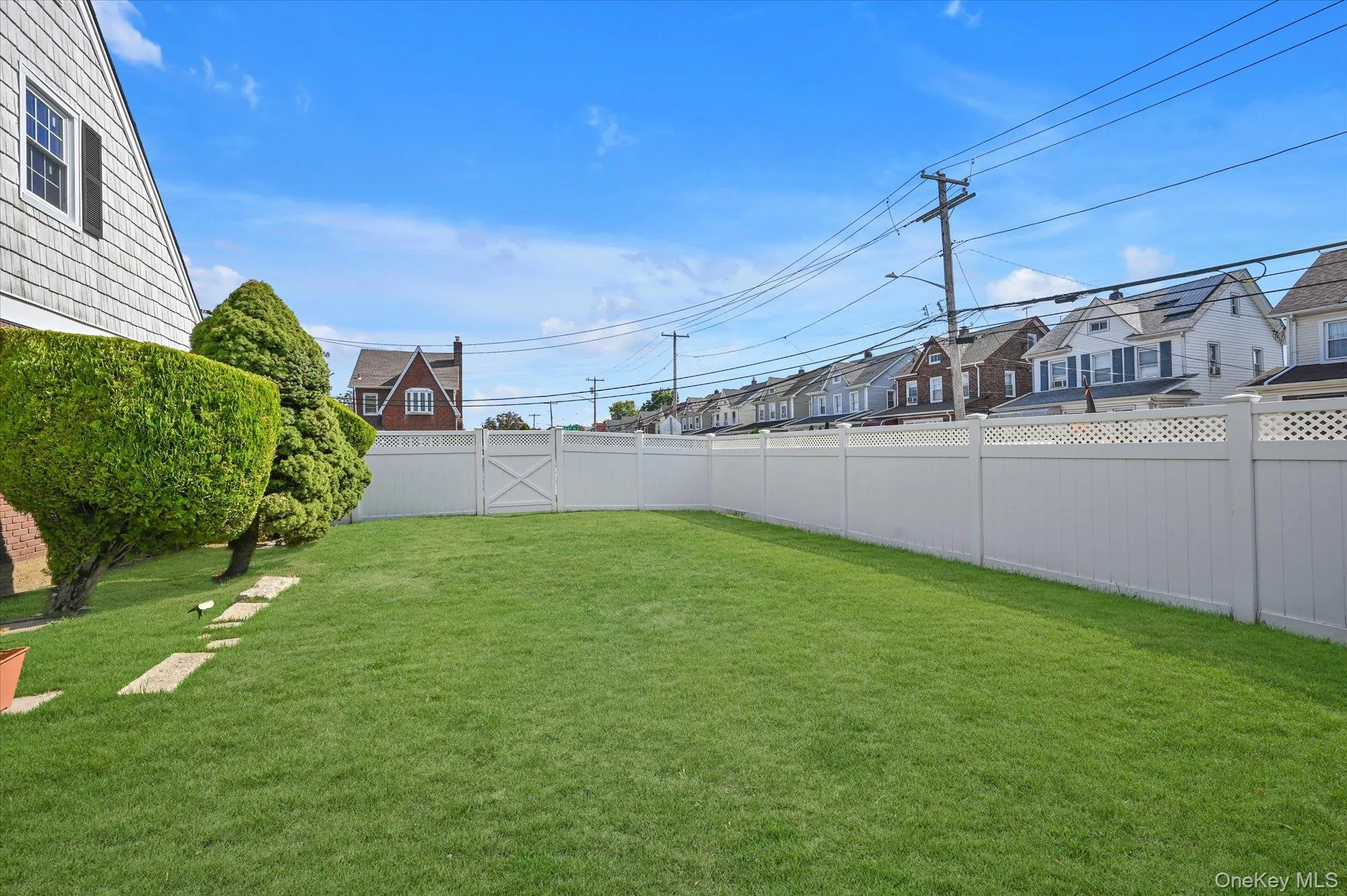Fenced backyard with a residential view Fenced backyard with a residential view