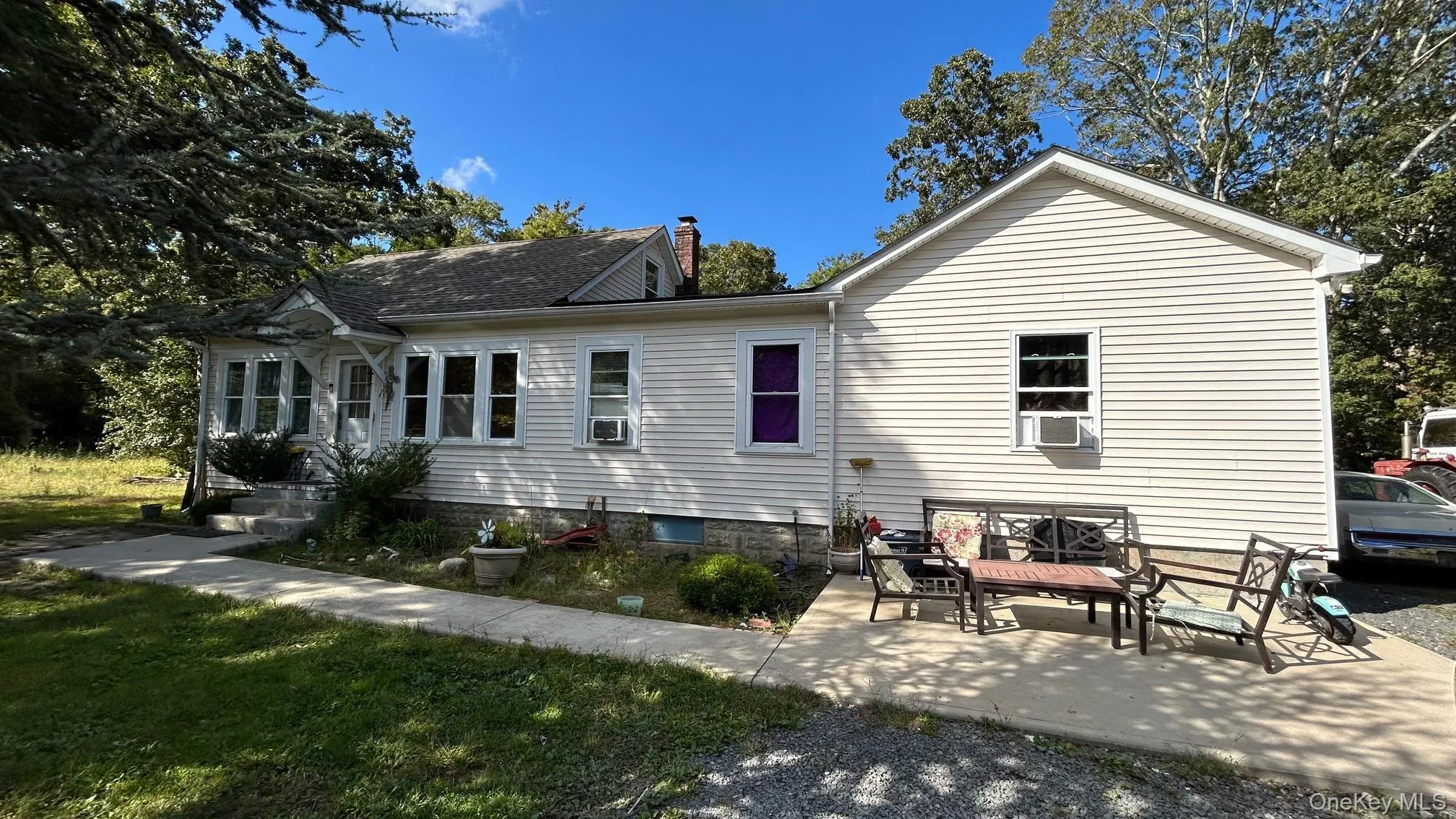 Rear view of property featuring a chimney, a patio area, and a yard Rear view of property featuring a chimney, a patio area, and a yard