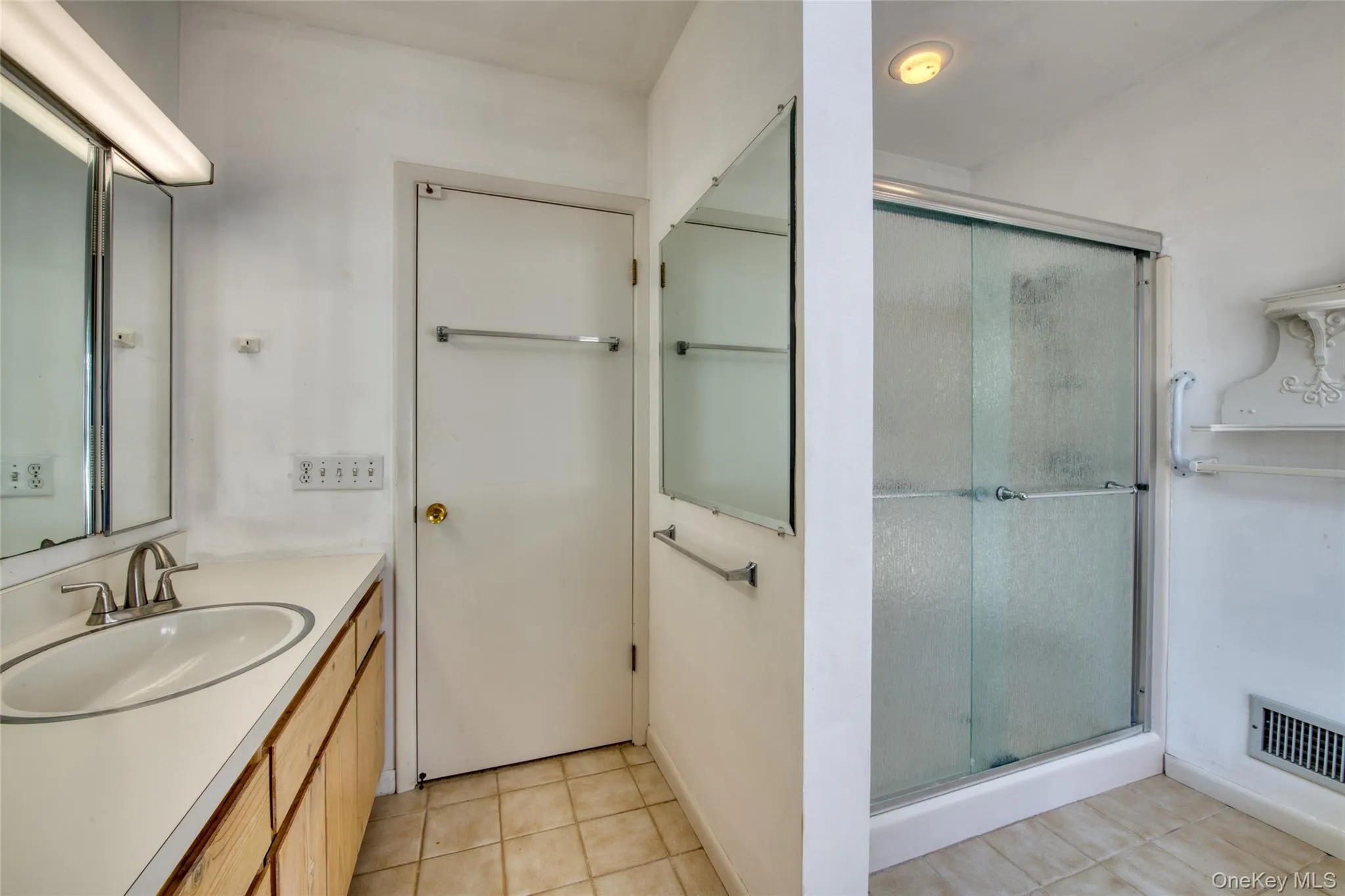 Bathroom with light tile patterned floors, vanity, and a shower stall Bathroom with light tile patterned floors, vanity, and a shower stall