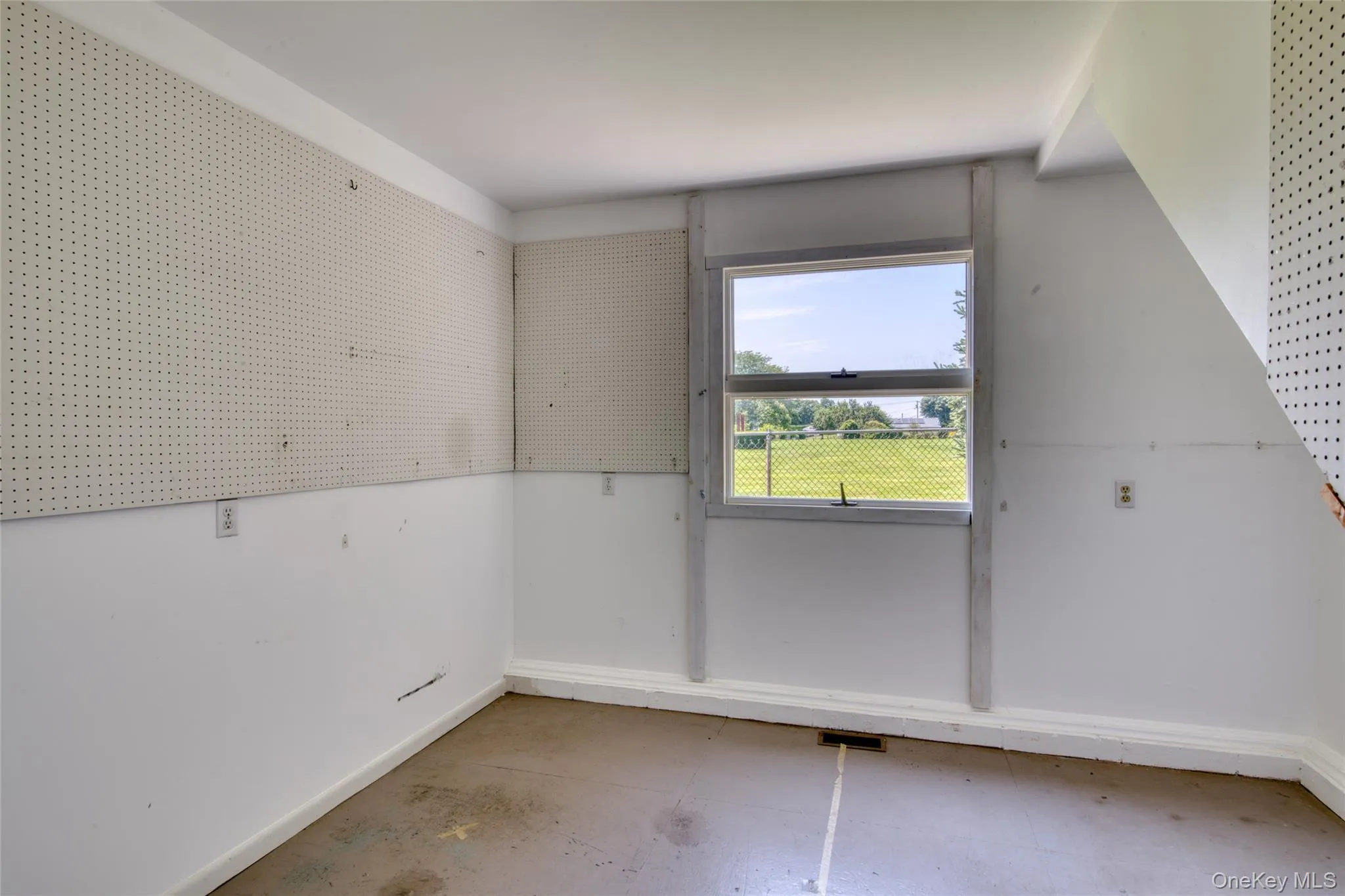 Empty room featuring concrete flooring and baseboards Empty room featuring concrete flooring and baseboards
