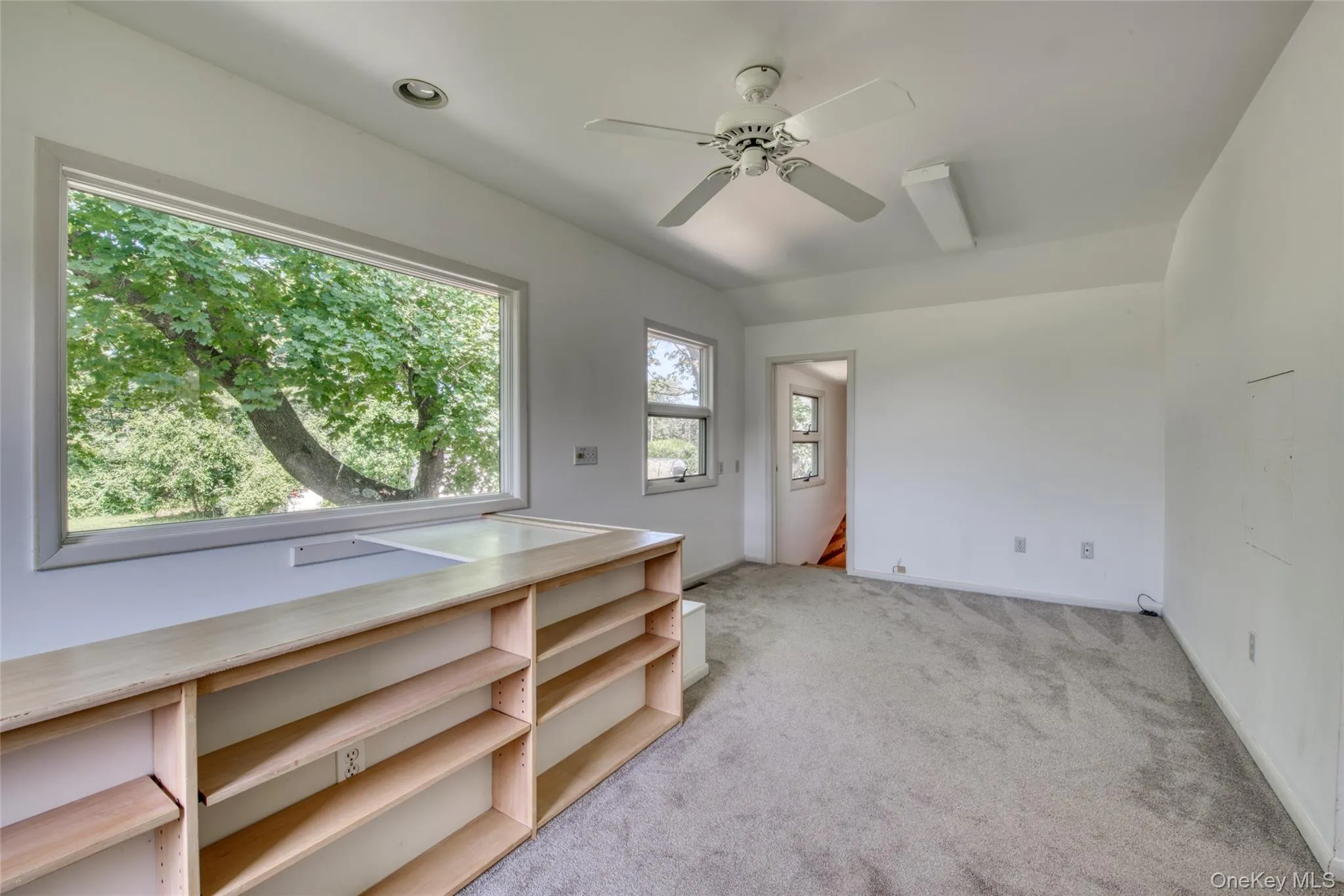 Empty room featuring light colored carpet and a ceiling fan Empty room featuring light colored carpet and a ceiling fan