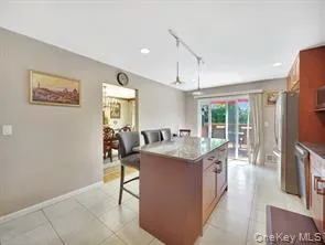 Kitchen featuring a breakfast bar area, a center island, decorative light fixtures, stainless steel appliances, and recessed lighting Kitchen featuring a breakfast bar area, a center island, decorative light fixtures, stainless steel appliances, and recessed lighting