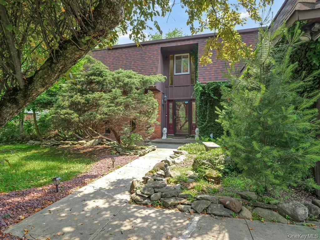 Property entrance with a shingled roof, mansard roof, and brick siding Property entrance with a shingled roof, mansard roof, and brick siding