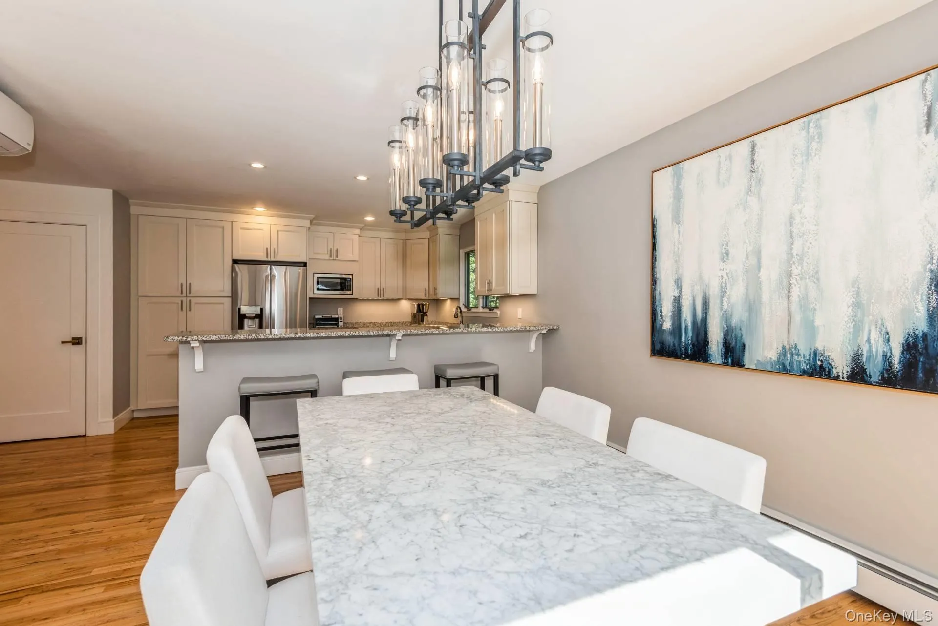 Dining room with recessed lighting, baseboard heating, light wood-type flooring, and a wall unit AC Dining room with recessed lighting, baseboard heating, light wood-type flooring, and a wall unit AC