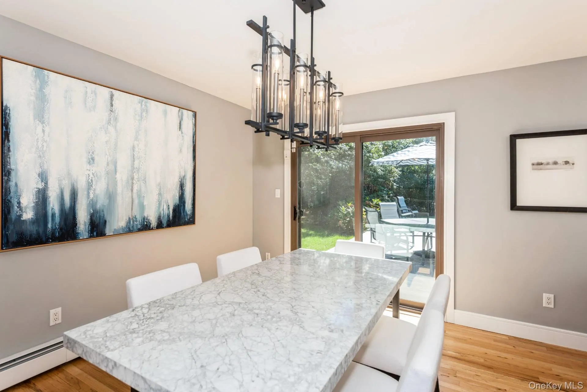 Dining area featuring a chandelier, light wood finished floors, and baseboard heating Dining area featuring a chandelier, light wood finished floors, and baseboard heating