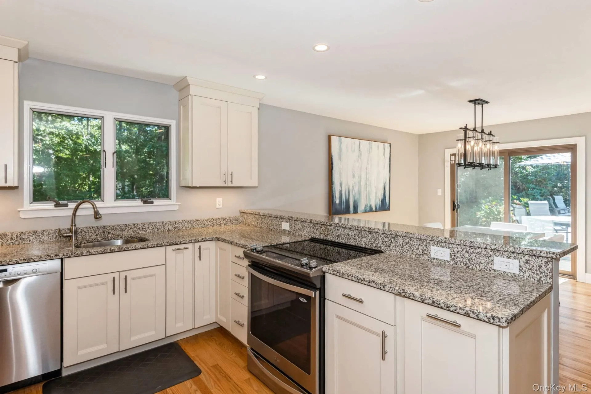 Kitchen featuring a peninsula, appliances with stainless steel finishes, light wood finished floors, light stone counters, and recessed lighting Kitchen featuring a peninsula, appliances with stainless steel finishes, light wood finished floors, light stone counters, and recessed lighting
