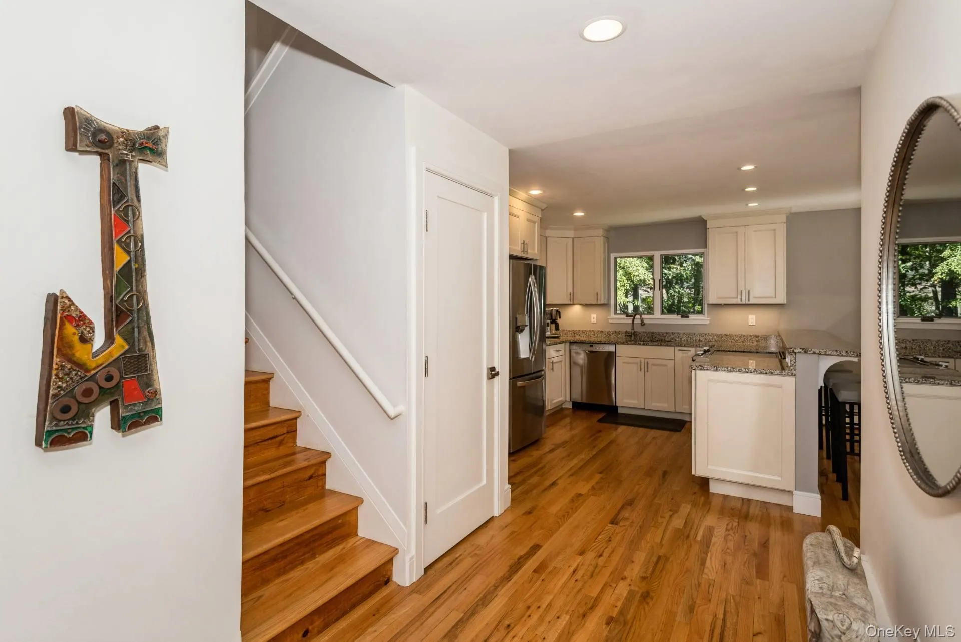 Kitchen with recessed lighting, dark wood-type flooring, light stone countertops, a peninsula, and appliances with stainless steel finishes Kitchen with recessed lighting, dark wood-type flooring, light stone countertops, a peninsula, and appliances with stainless steel finishes