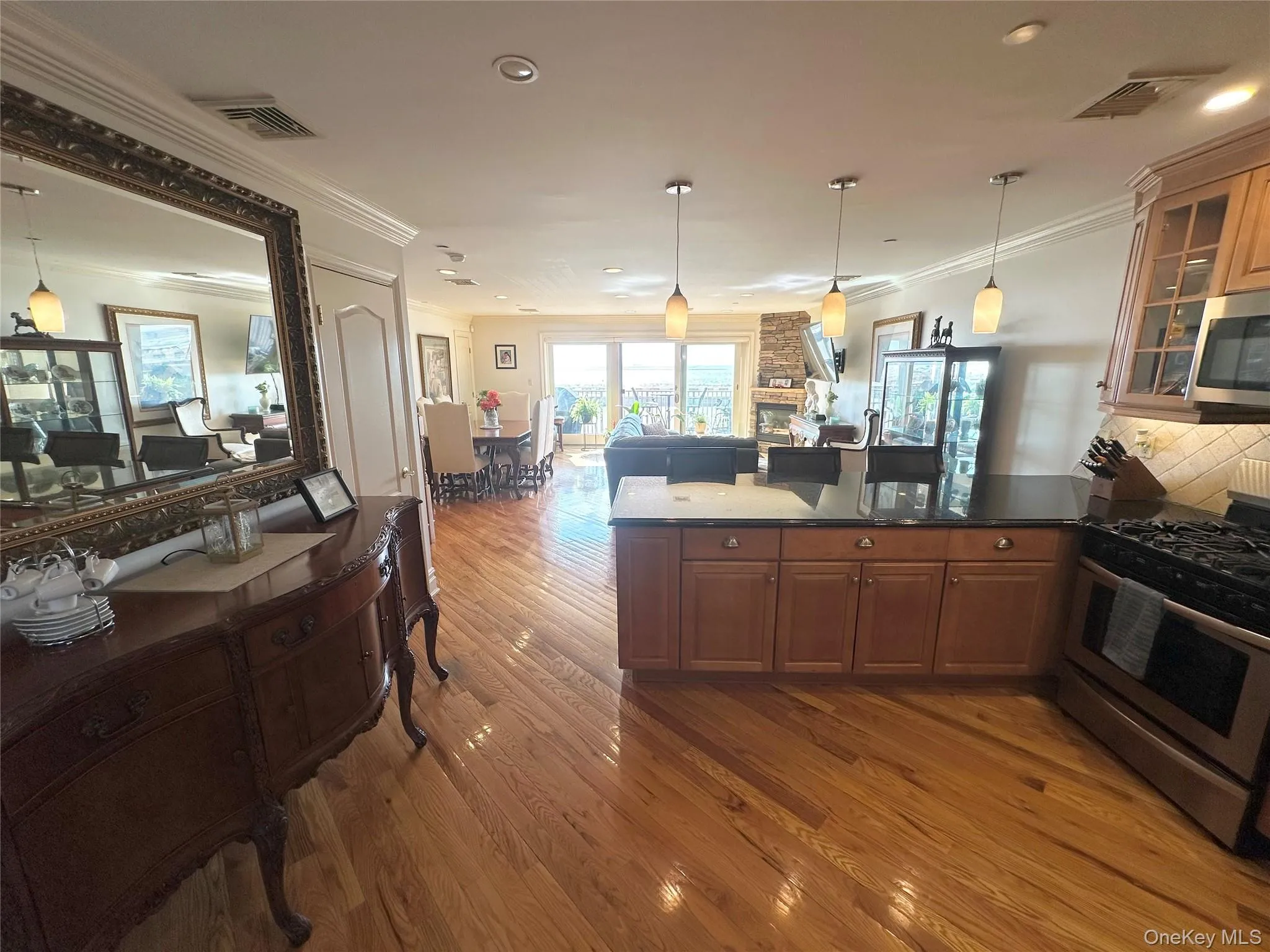 Kitchen with stainless steel appliances, a peninsula, crown molding, pendant lighting, and glass insert cabinets Kitchen with stainless steel appliances, a peninsula, crown molding, pendant lighting, and glass insert cabinets