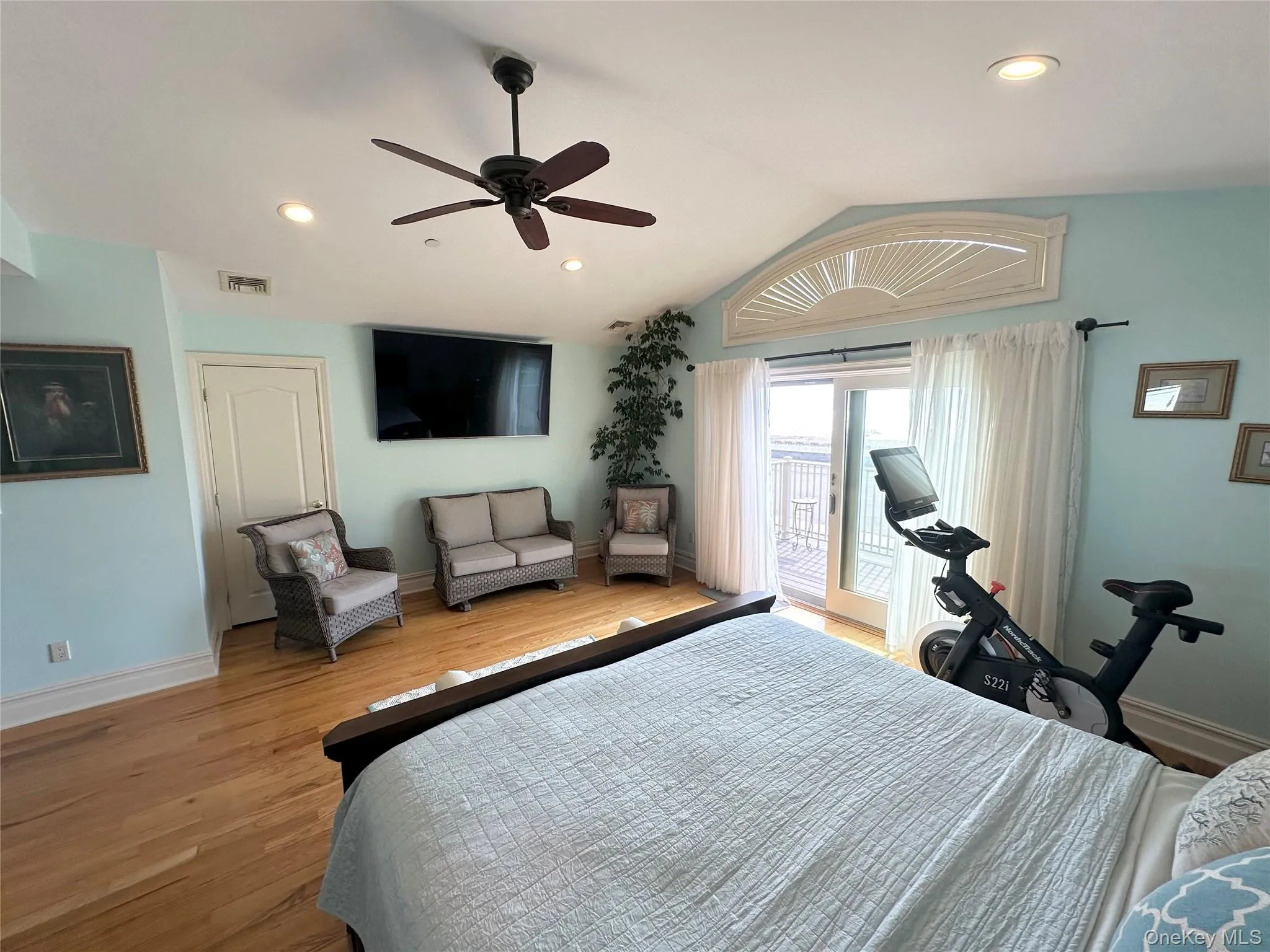 Bedroom featuring lofted ceiling, access to exterior, recessed lighting, light wood-type flooring, and ceiling fan Bedroom featuring lofted ceiling, access to exterior, recessed lighting, light wood-type flooring, and ceiling fan