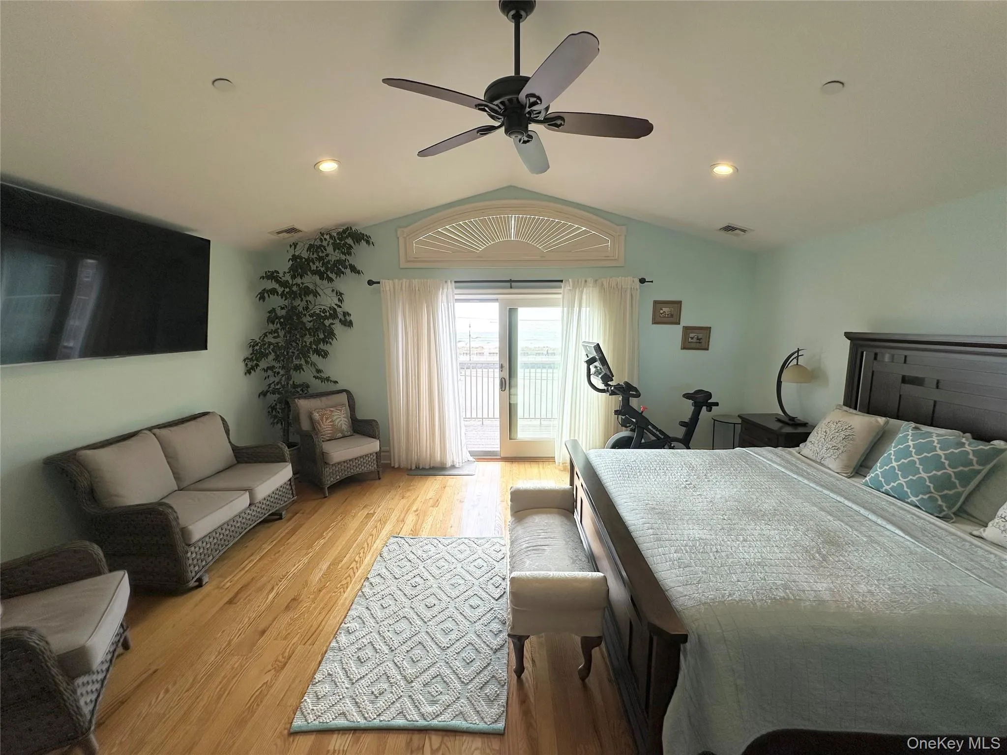 Bedroom with vaulted ceiling, wood finished floors, access to outside, a ceiling fan, and recessed lighting Bedroom with vaulted ceiling, wood finished floors, access to outside, a ceiling fan, and recessed lighting