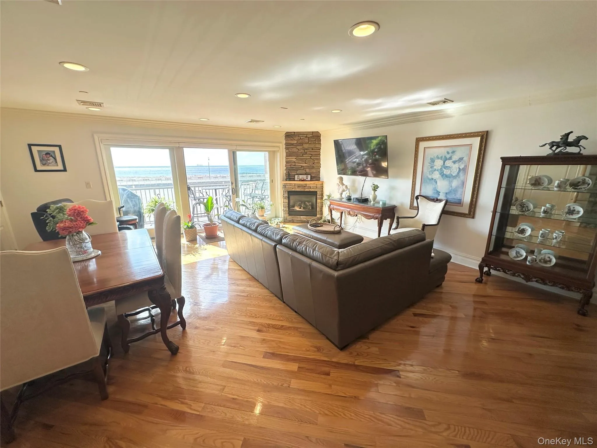 Living room with light wood-style flooring, a fireplace, recessed lighting, and ornamental molding Living room with light wood-style flooring, a fireplace, recessed lighting, and ornamental molding