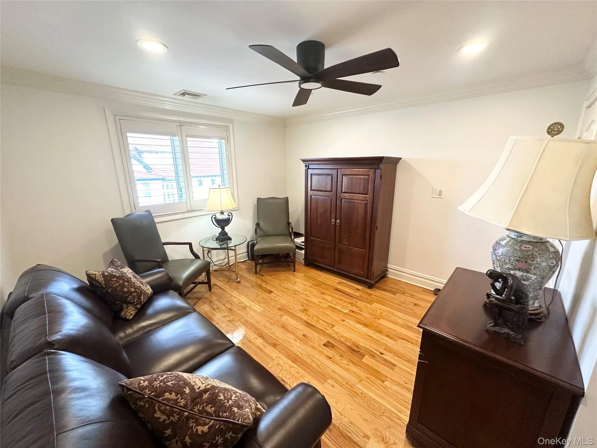 Living room with crown molding, light wood-style flooring, and ceiling fan Living room with crown molding, light wood-style flooring, and ceiling fan