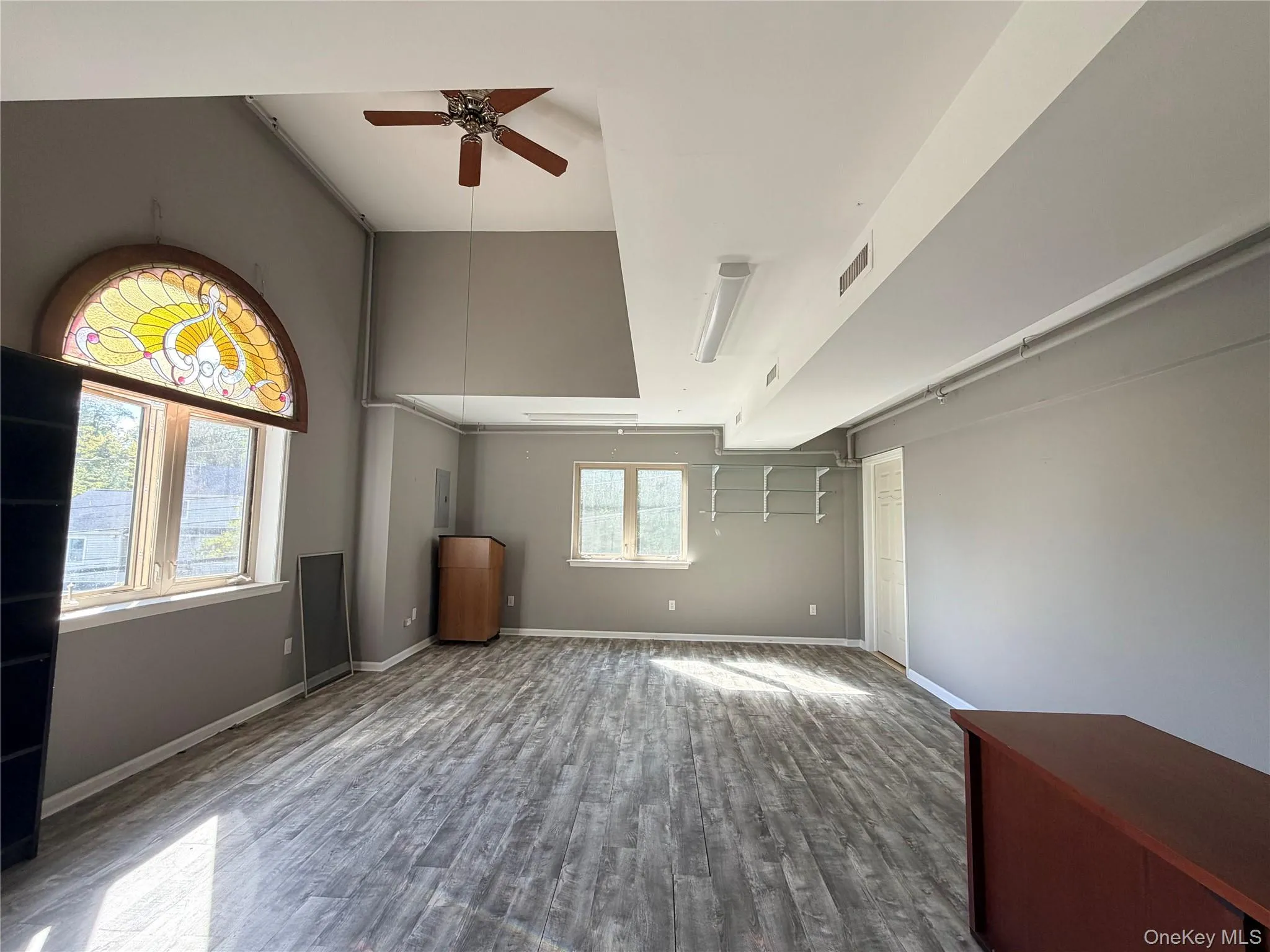Unfurnished living room with wood finished floors and a ceiling fan Unfurnished living room with wood finished floors and a ceiling fan