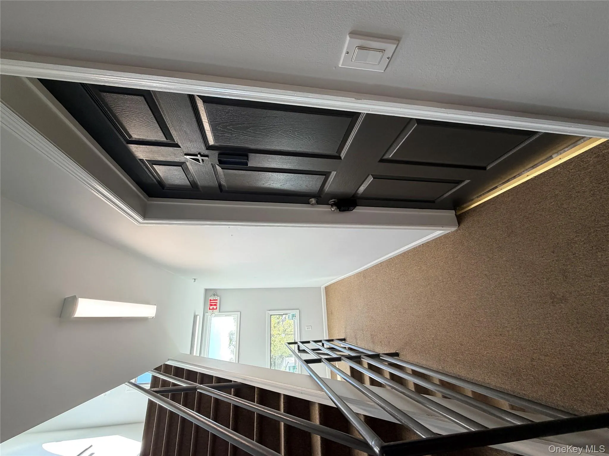 Hallway with carpet flooring and stairway Hallway with carpet flooring and stairway