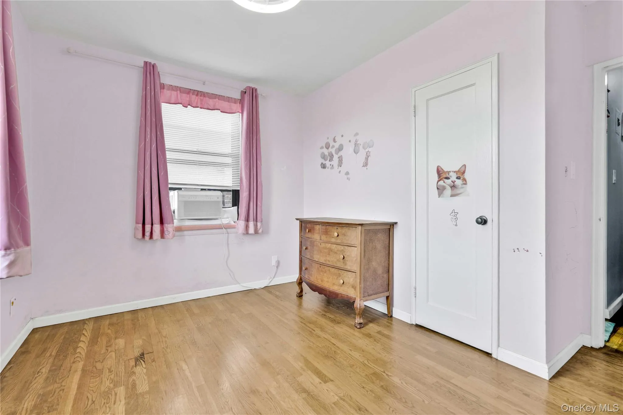 Bedroom with baseboards and light wood finished floors Bedroom with baseboards and light wood finished floors
