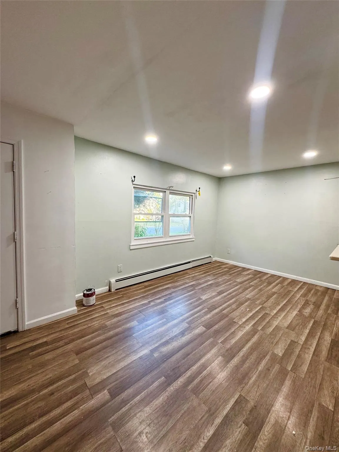 Below grade area with a baseboard radiator, wood finished floors, and recessed lighting Below grade area with a baseboard radiator, wood finished floors, and recessed lighting