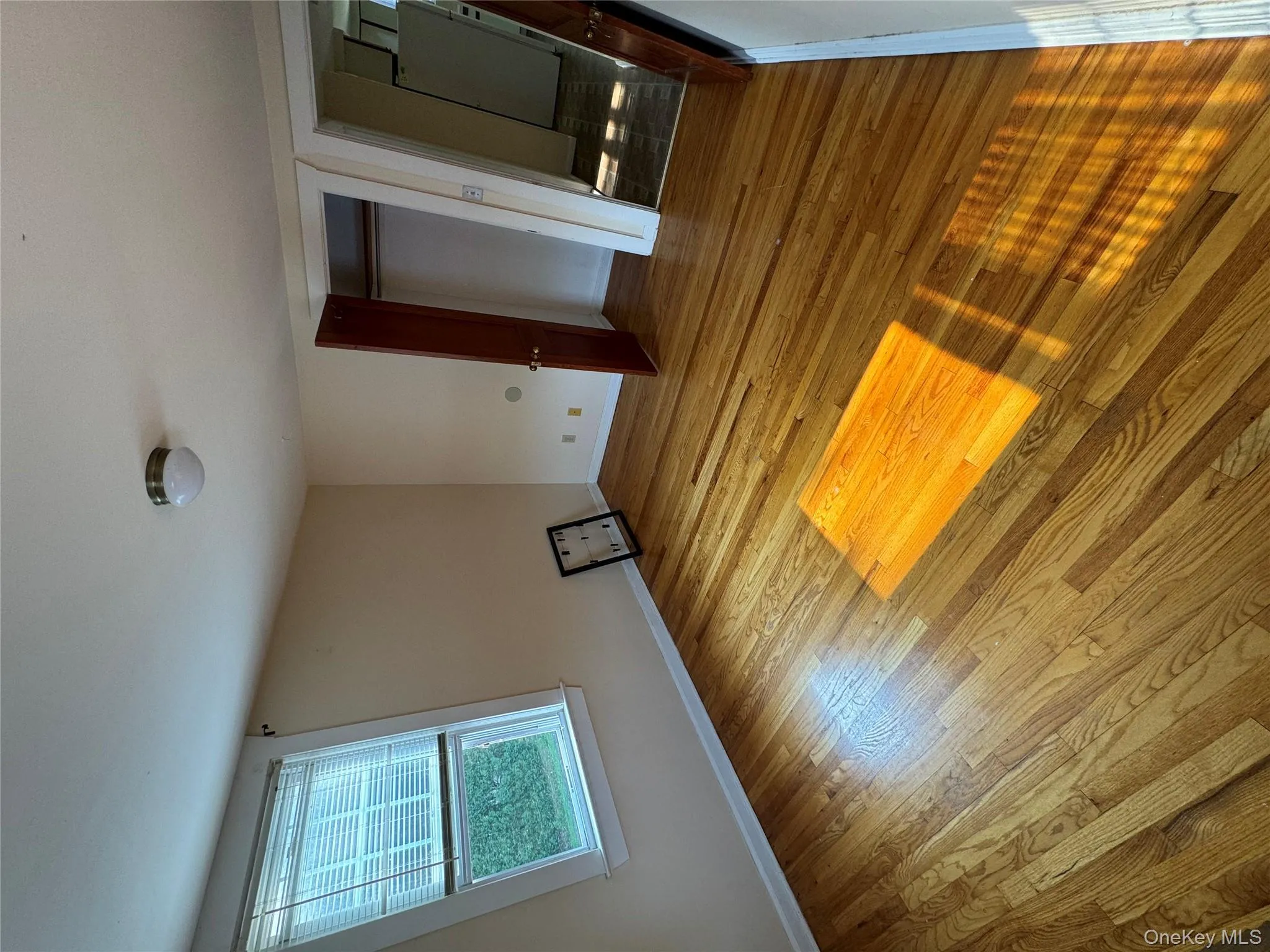 Unfurnished bedroom featuring refrigerator, light wood-style flooring, and a closet Unfurnished bedroom featuring refrigerator, light wood-style flooring, and a closet