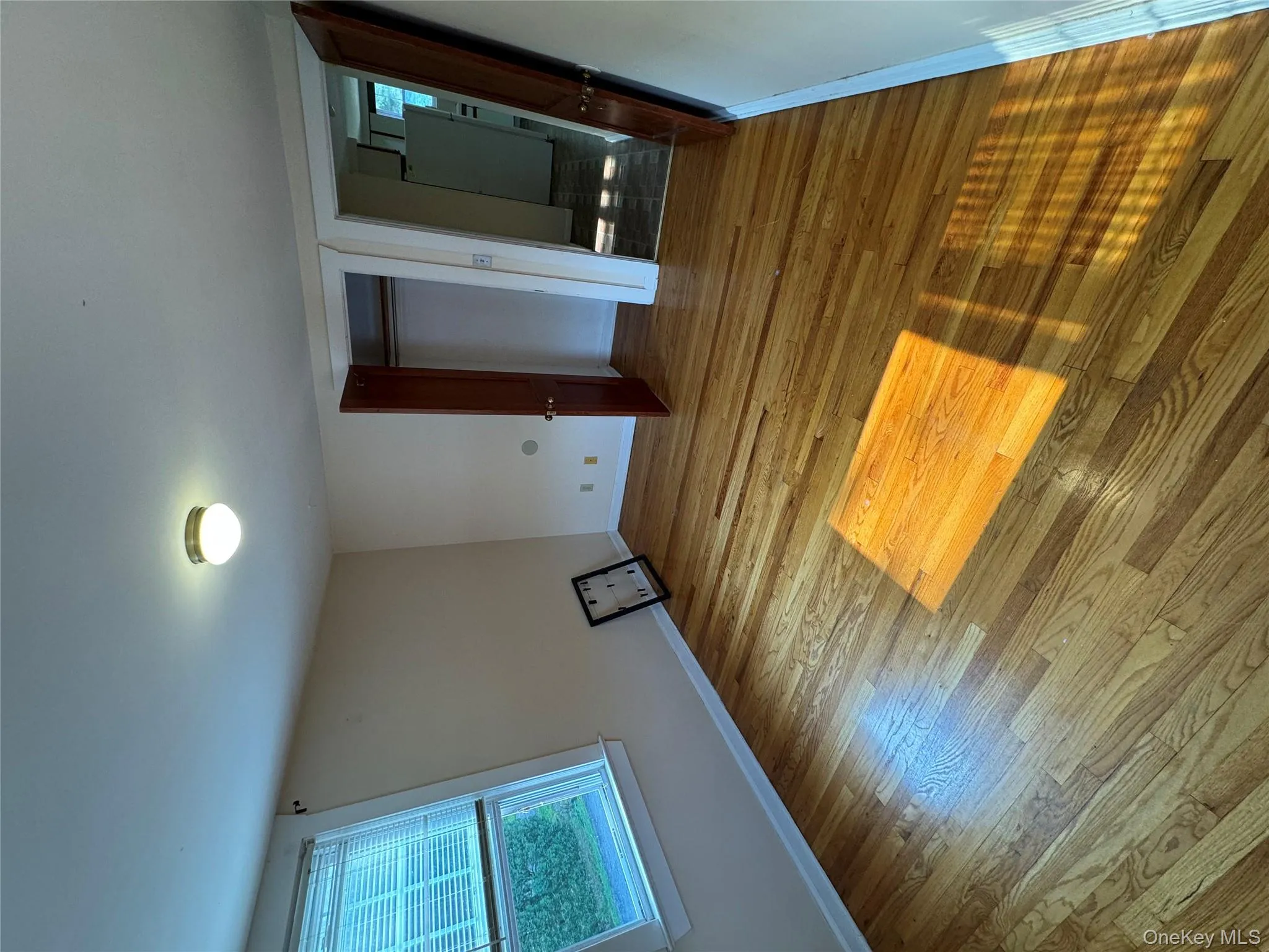 Unfurnished bedroom featuring a closet, wood finished floors, and refrigerator Unfurnished bedroom featuring a closet, wood finished floors, and refrigerator