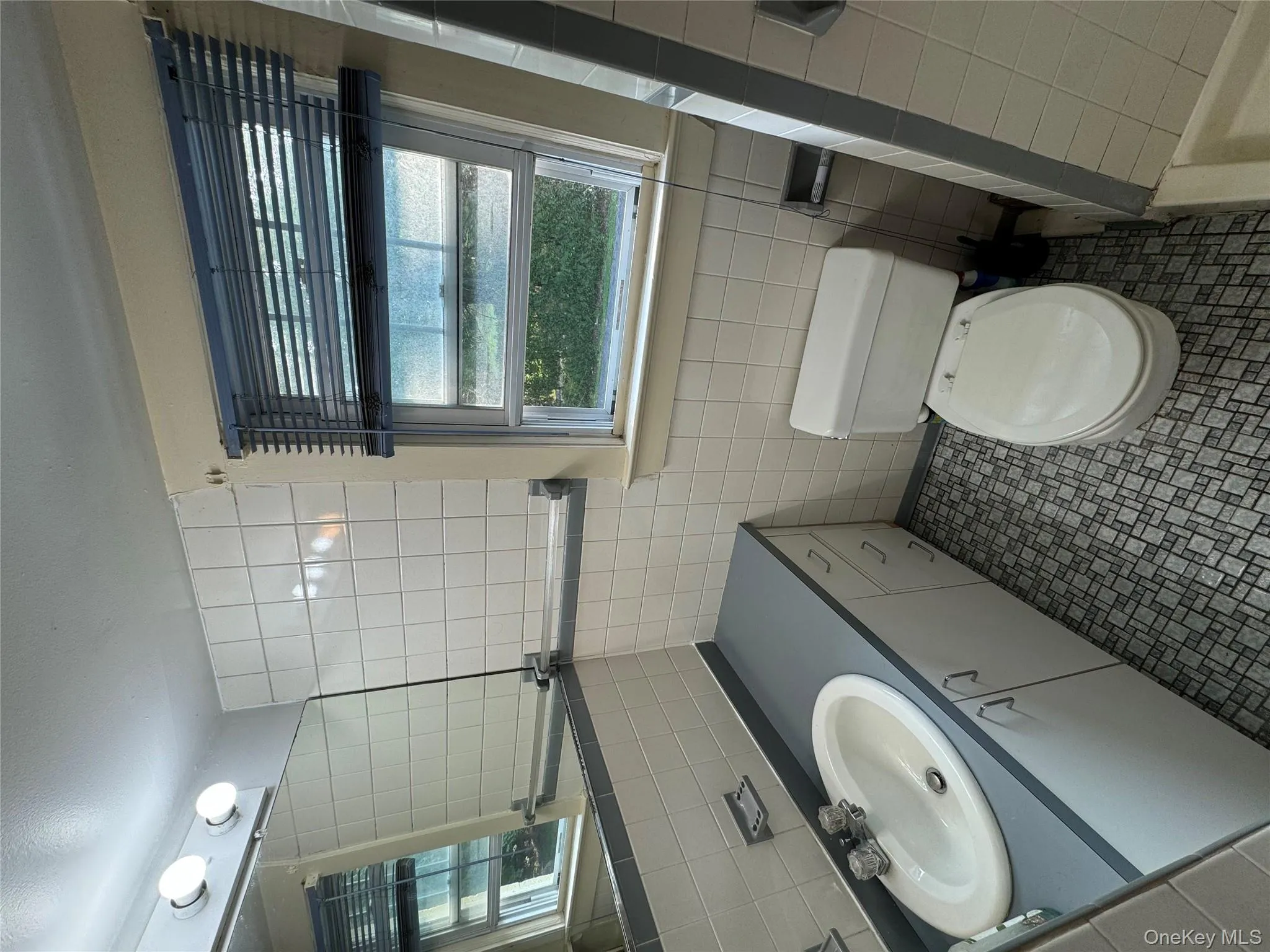 Full bath with tile walls, vanity, and tile patterned flooring Full bath with tile walls, vanity, and tile patterned flooring