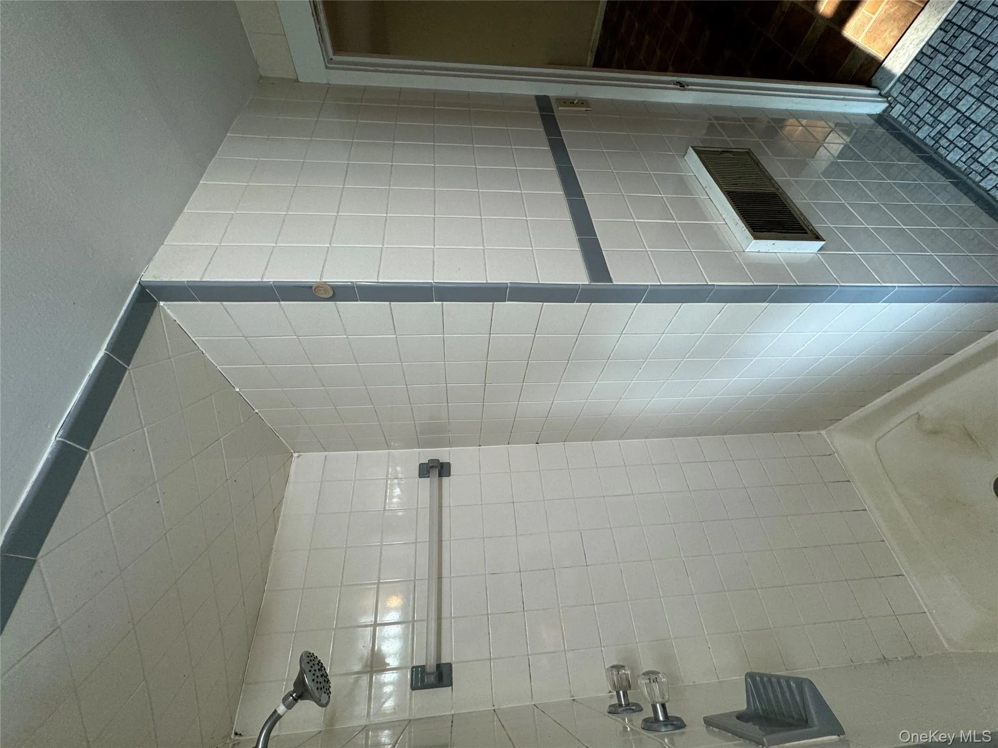 Bathroom featuring a shower stall, tile walls, and tile patterned flooring Bathroom featuring a shower stall, tile walls, and tile patterned flooring