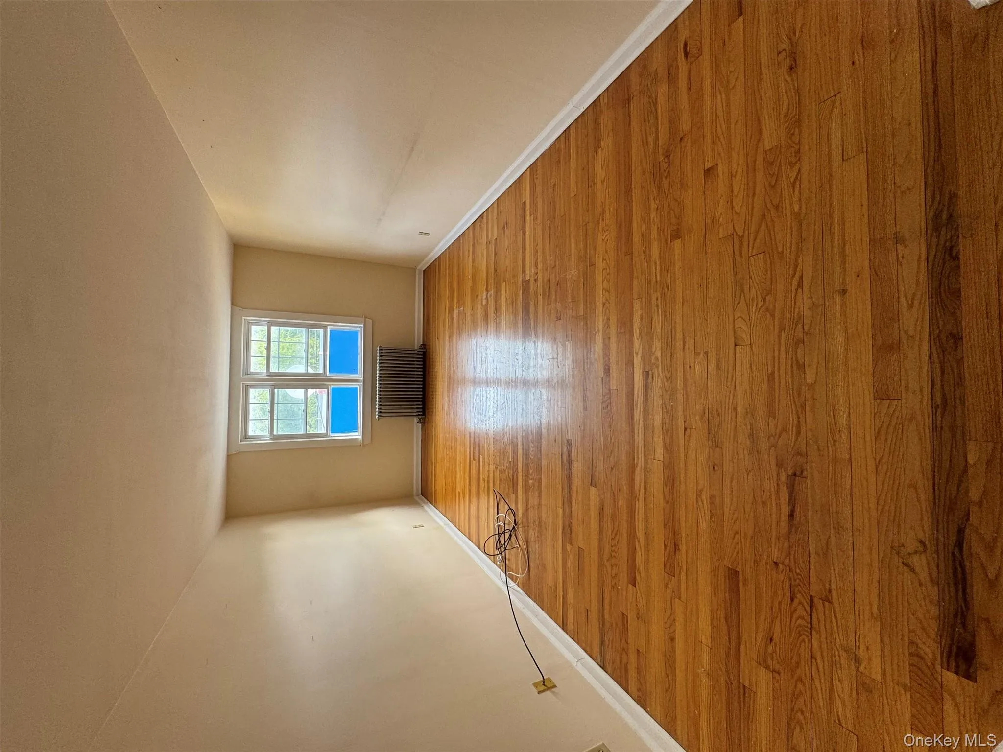 Spare room with light wood-type flooring and radiator heating unit Spare room with light wood-type flooring and radiator heating unit