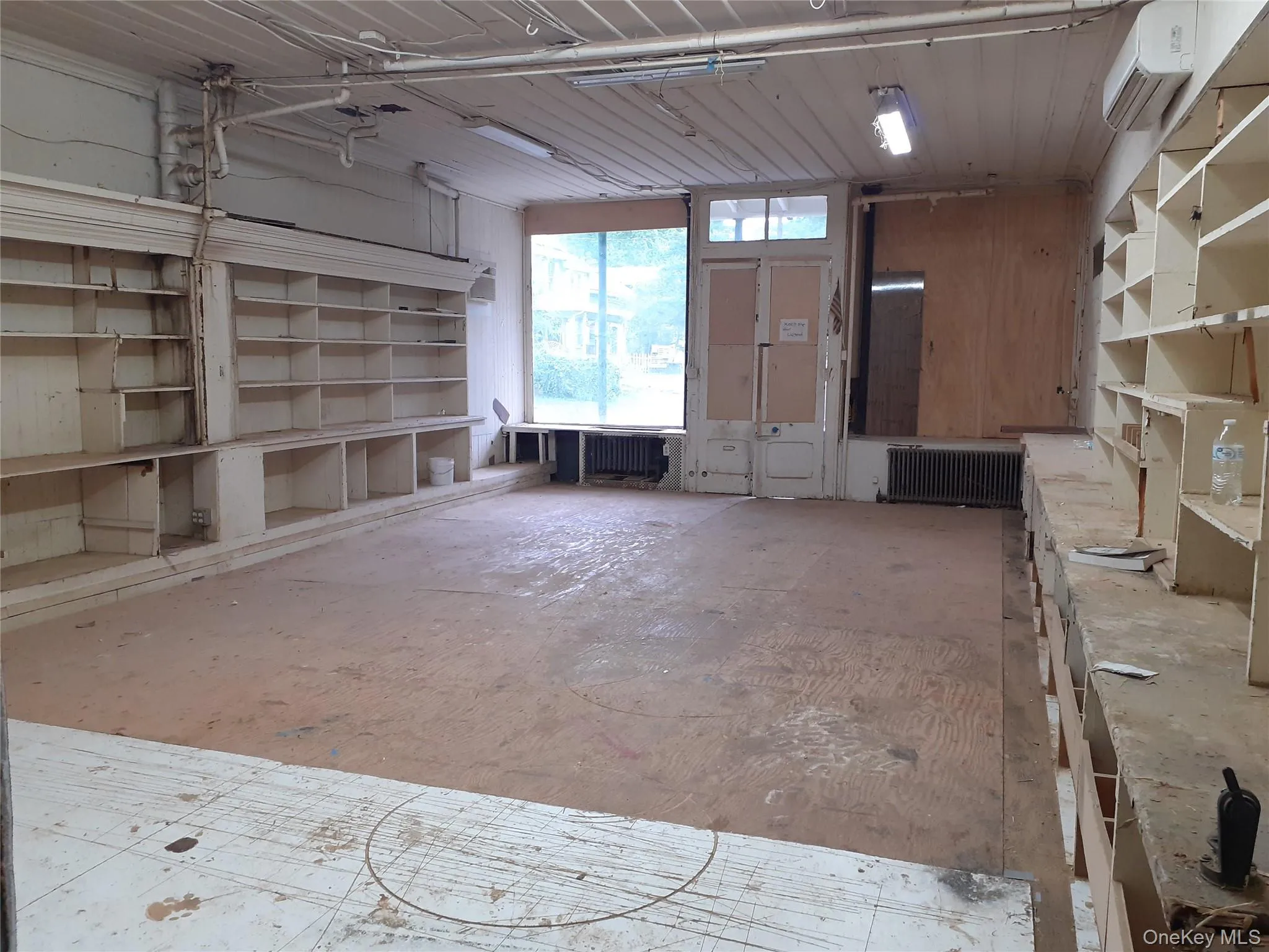 Garage featuring radiator heating unit and a wall mounted AC Garage featuring radiator heating unit and a wall mounted AC