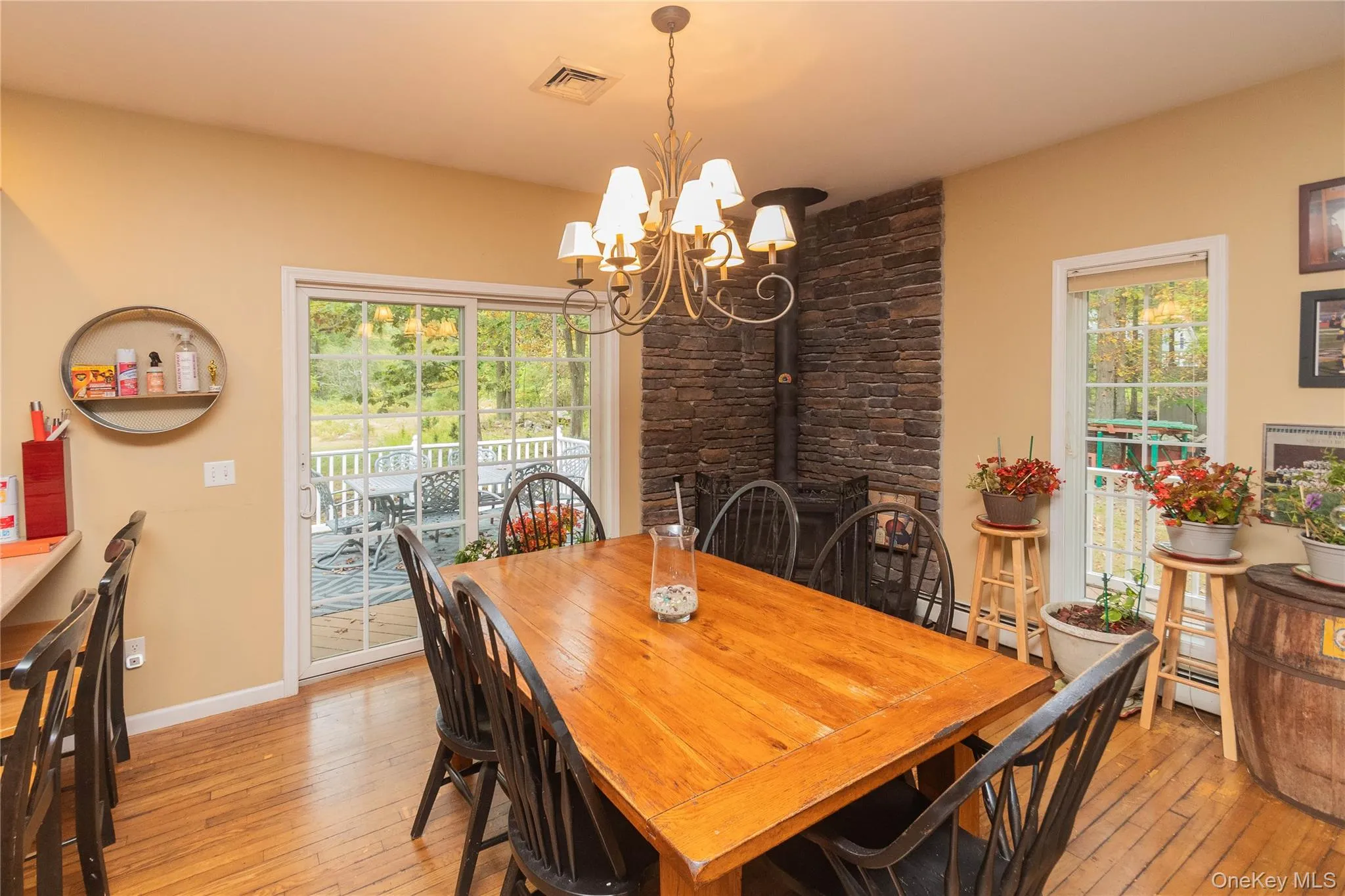 Dining area featuring healthy amount of natural light, light wood finished floors, a baseboard heating unit, and a chandelier Dining area featuring healthy amount of natural light, light wood finished floors, a baseboard heating unit, and a chandelier
