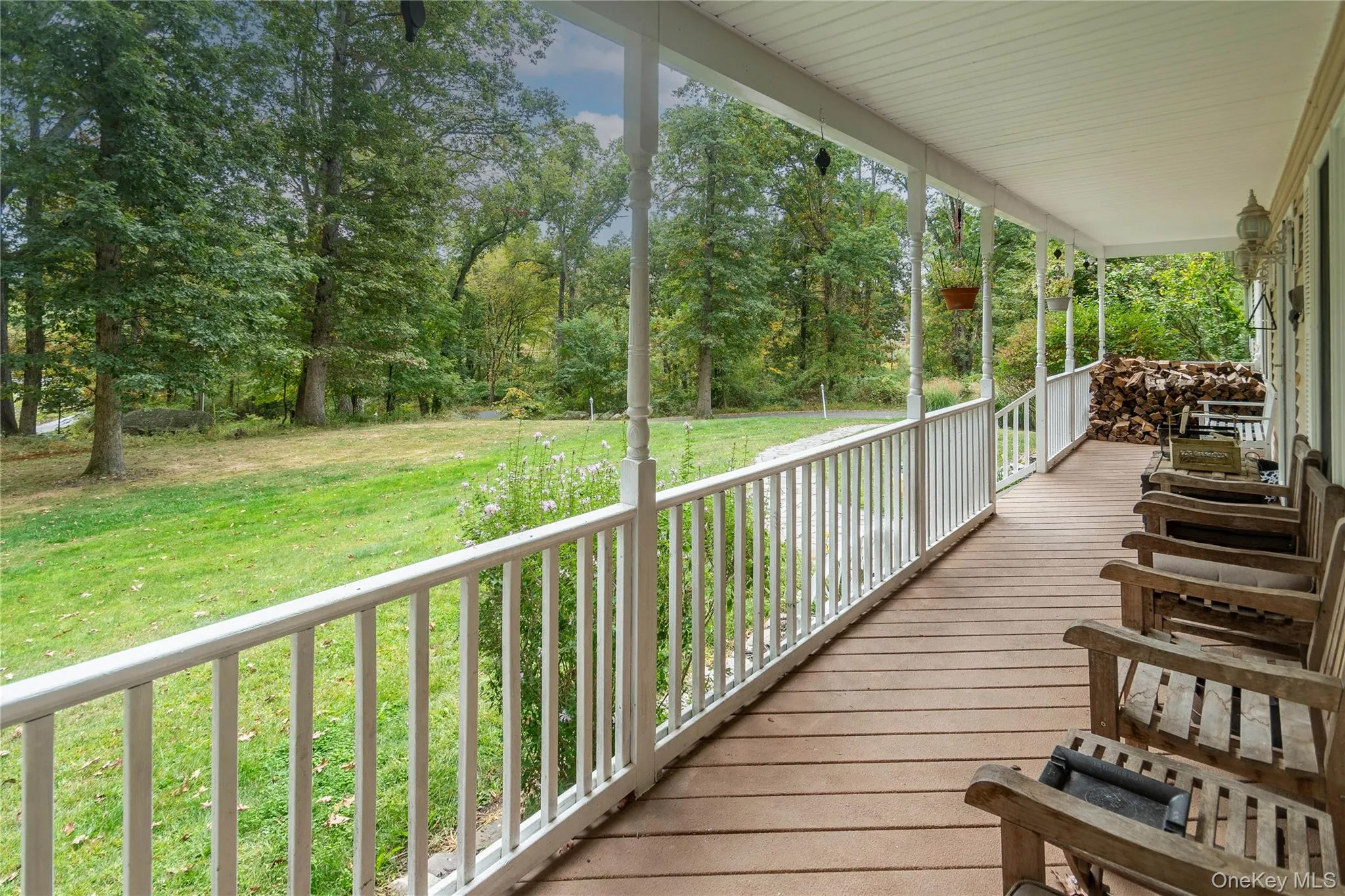 Wooden porch with a yard and view of wooded area Wooden porch with a yard and view of wooded area