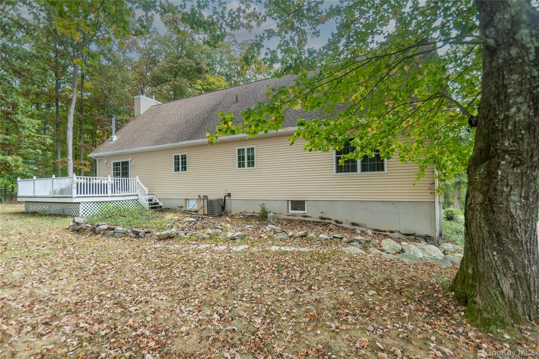 Rear view of property with a wooden deck, a chimney, and a shingled roof Rear view of property with a wooden deck, a chimney, and a shingled roof