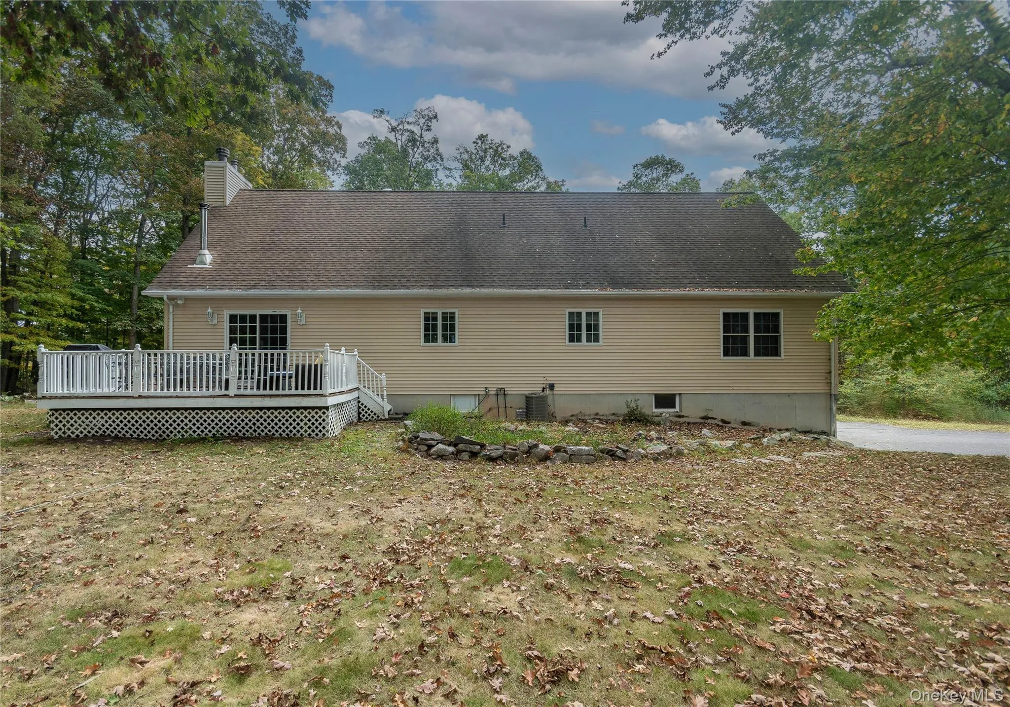 Rear view of property with a wooden deck, a chimney, and a shingled roof Rear view of property with a wooden deck, a chimney, and a shingled roof