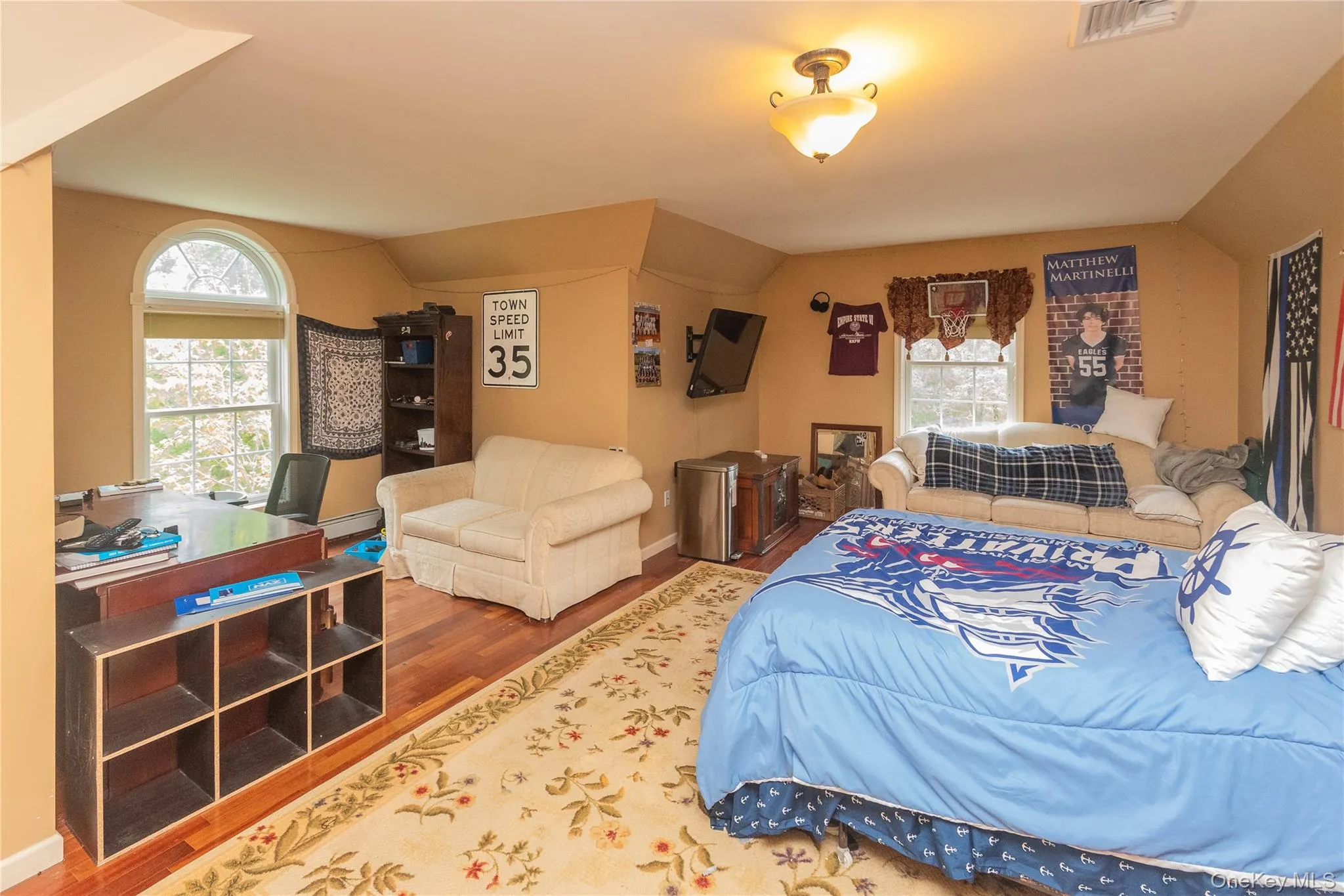 Bedroom featuring wood finished floors and lofted ceiling Bedroom featuring wood finished floors and lofted ceiling
